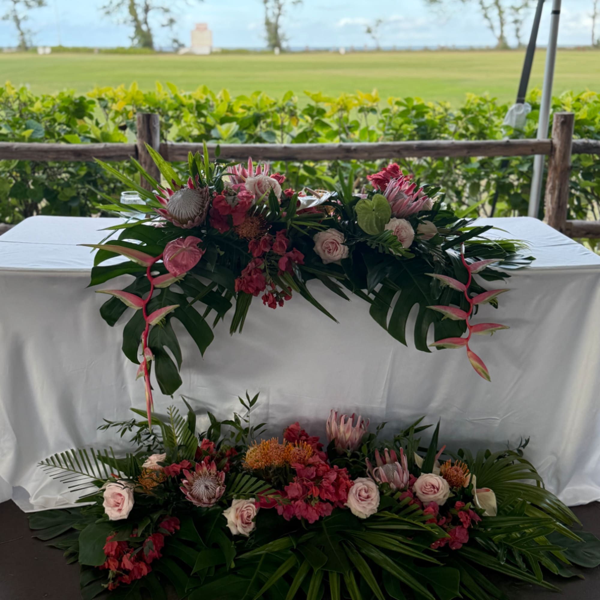 Wedding floral arrangements with pink and white blooms on a table and floor display