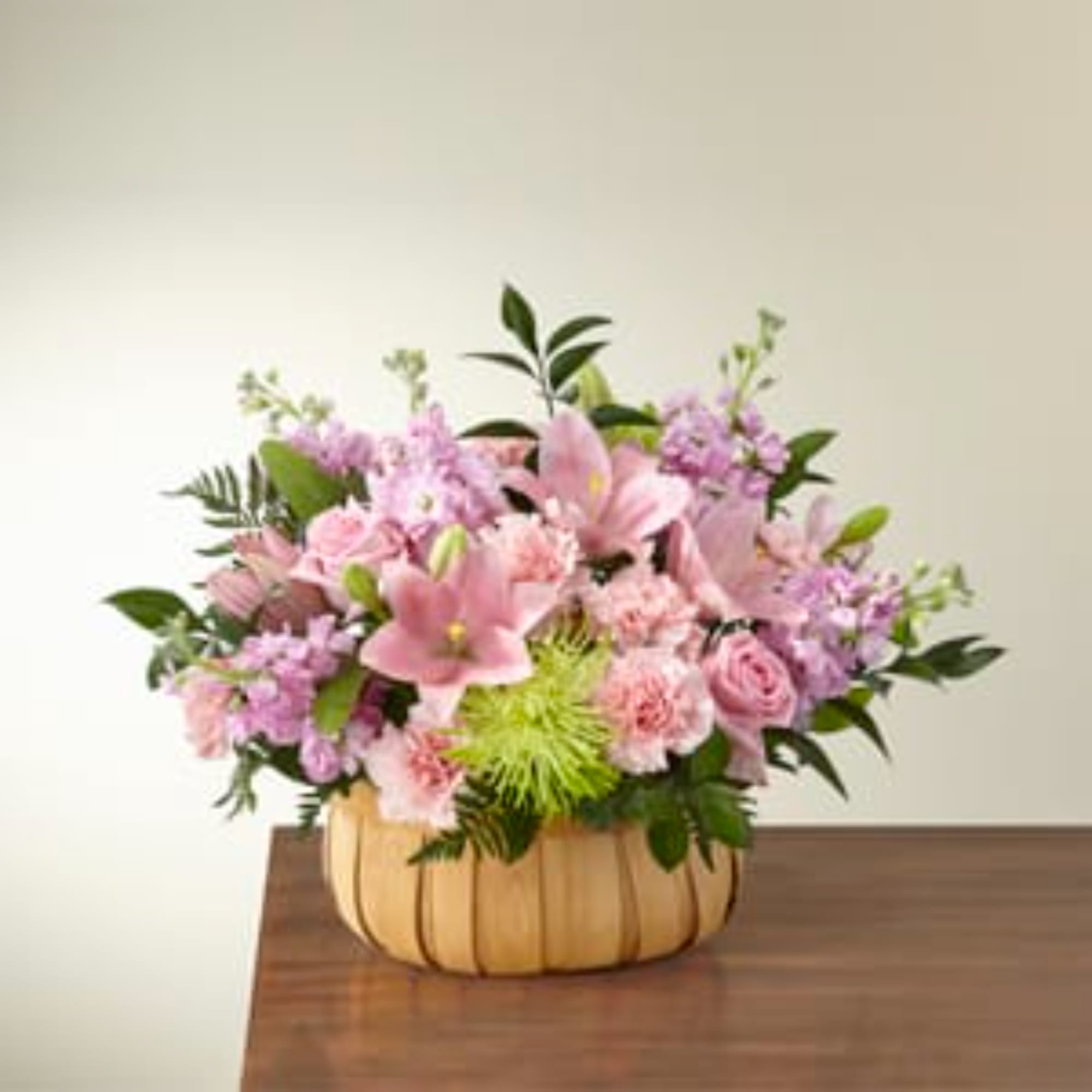 Pink and lavender bouquet in a tan pumpkin-shaped container