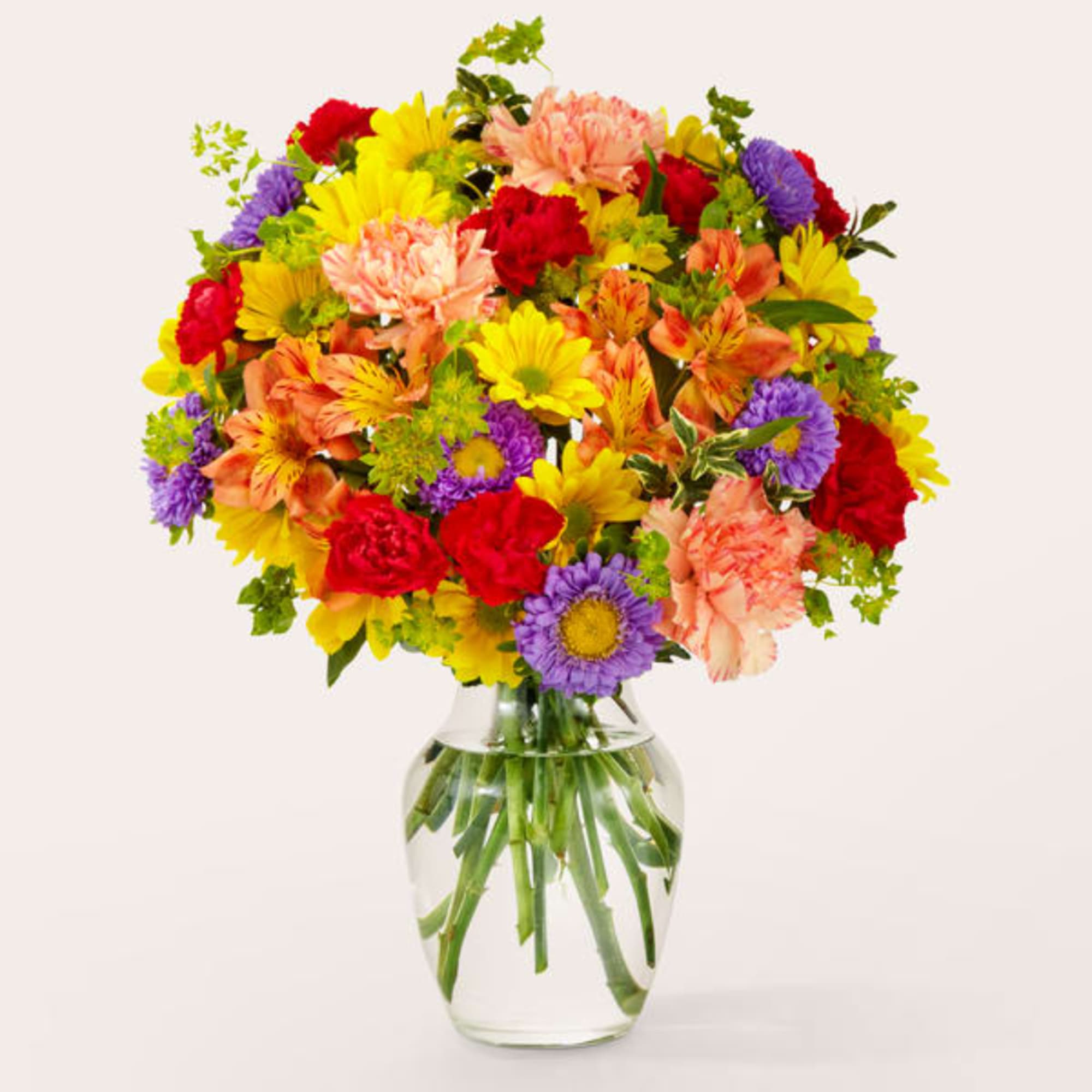 Mixed bouquet of colorful flowers in a clear glass vase