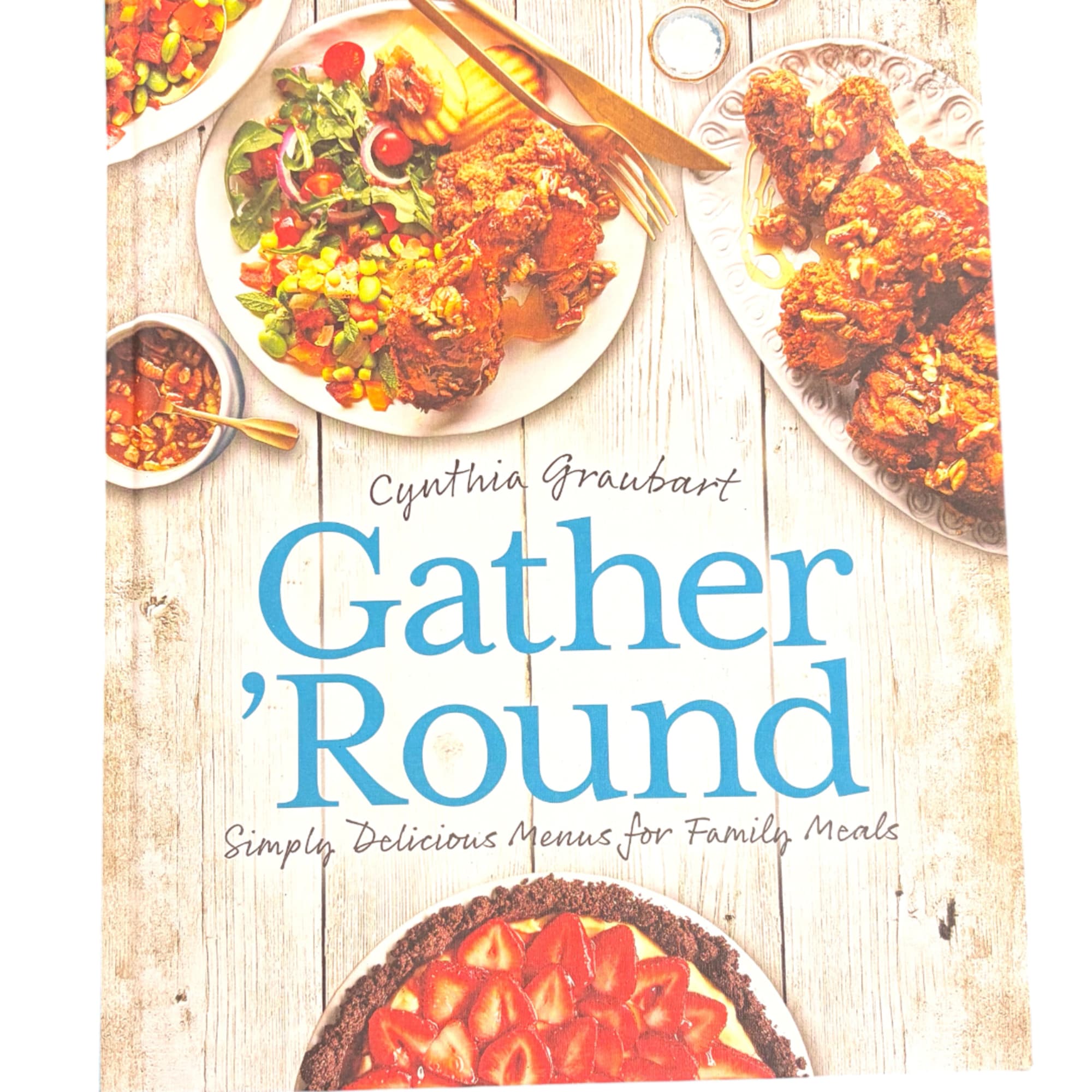 Cookbook cover with plated meals and the title Gather 'Round
