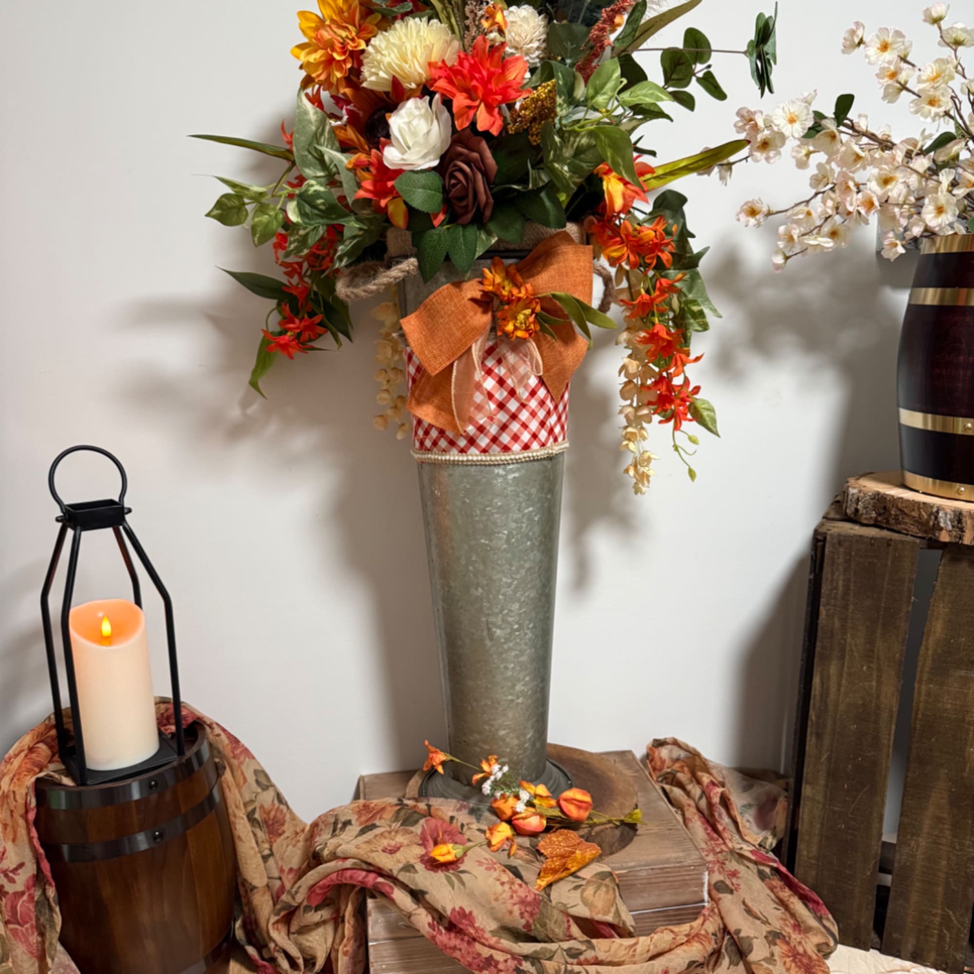 Tall autumn floral arrangement in a metal vase with orange and white flowers