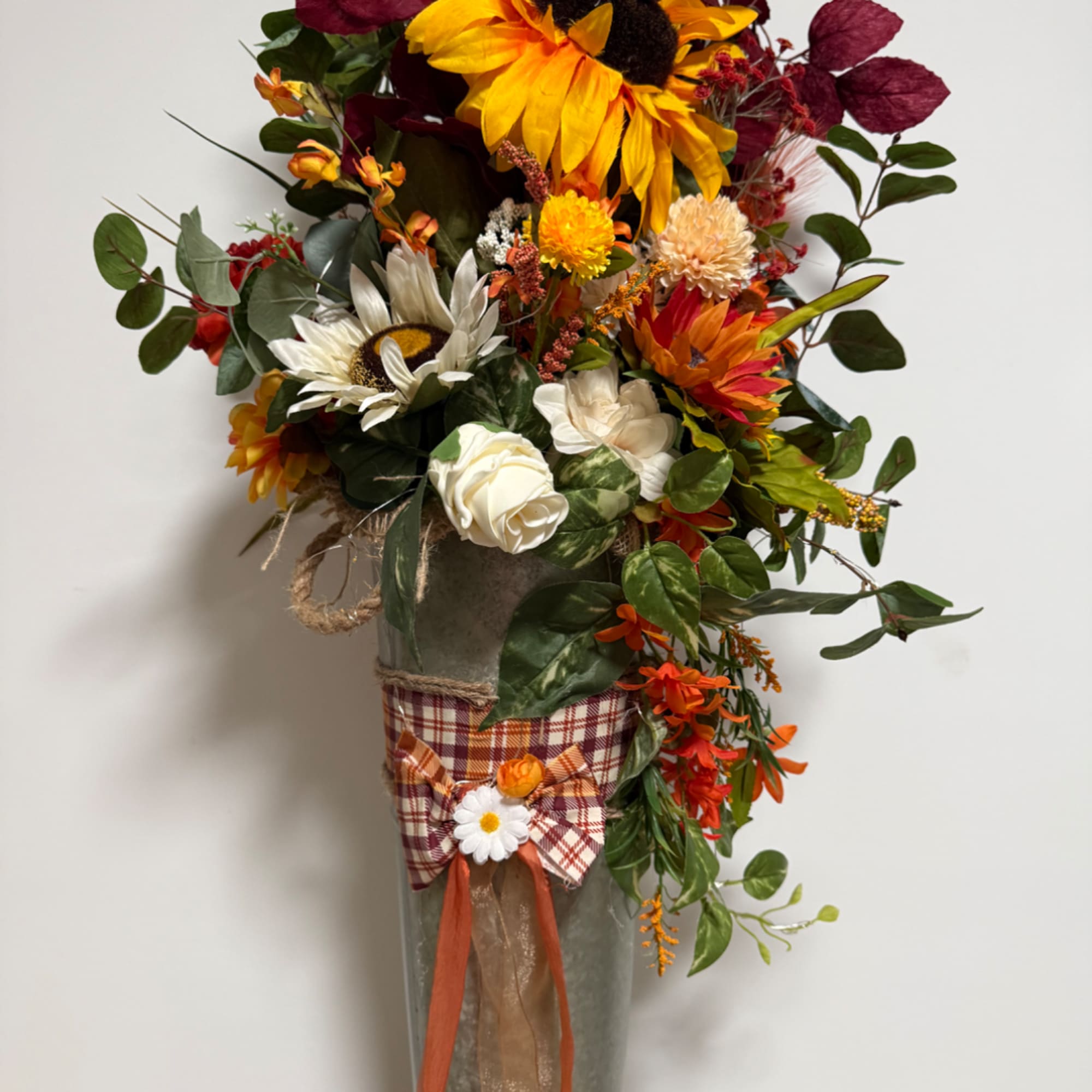 Tall autumn floral arrangement in a gray vase with sunflowers and white roses