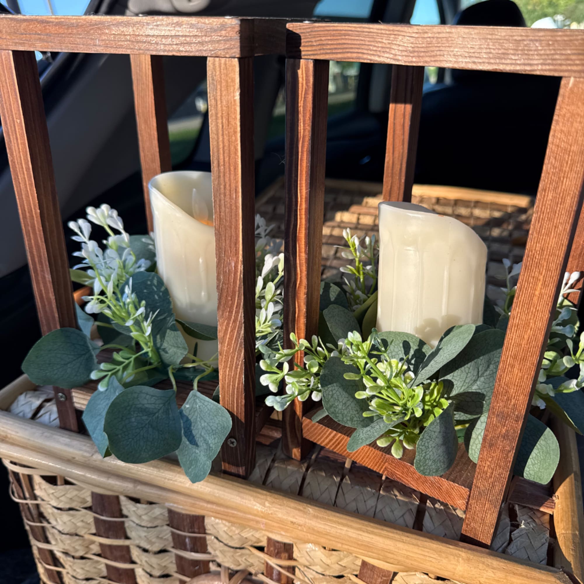 Wooden lantern with two pillar candles and white floral greenery accents