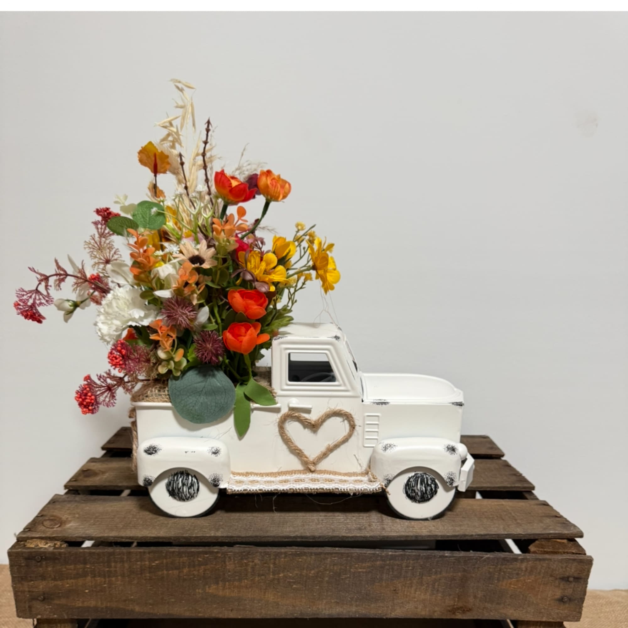 White decorative truck filled with colorful flowers
