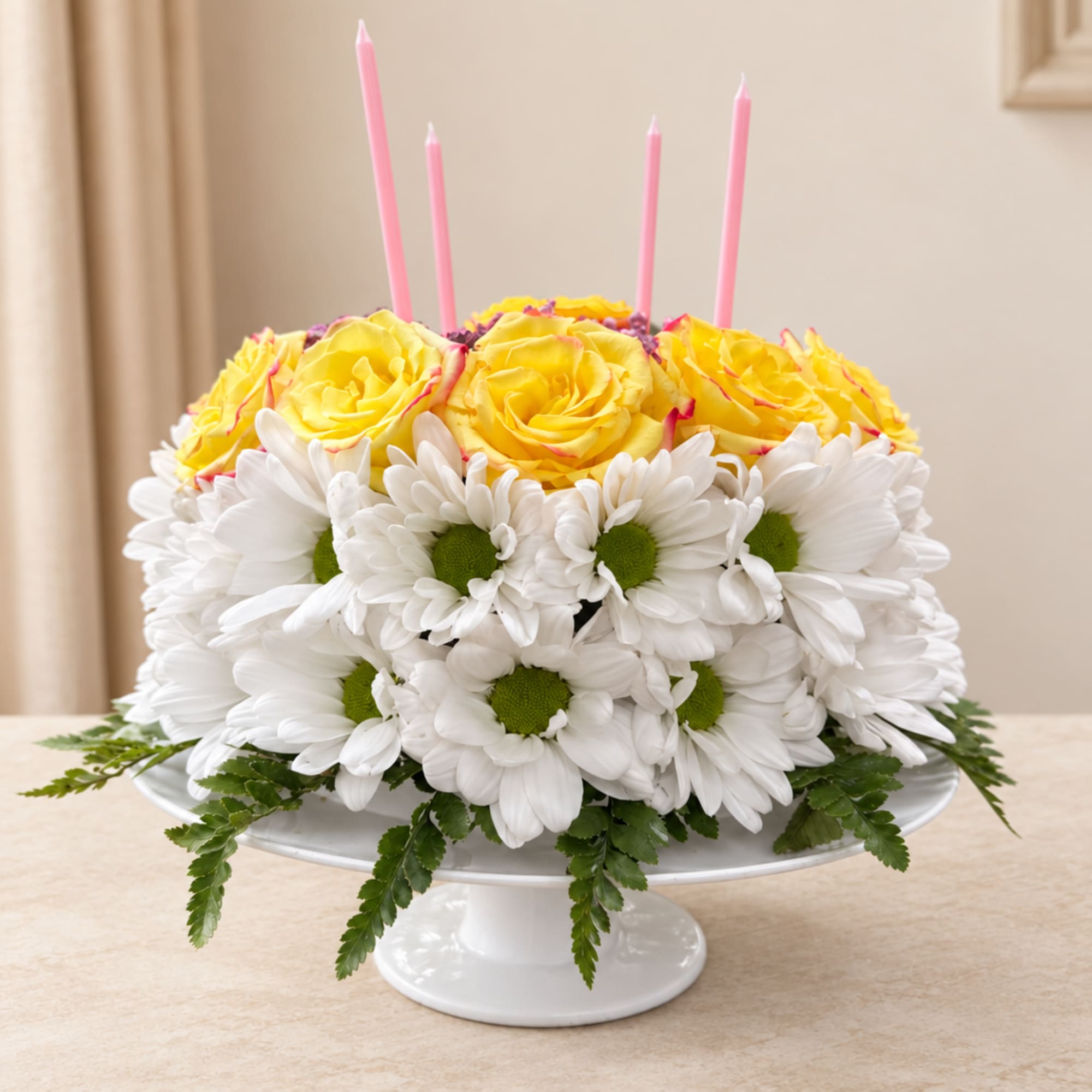 Yellow roses and white daisies on a white pedestal stand with pink candles