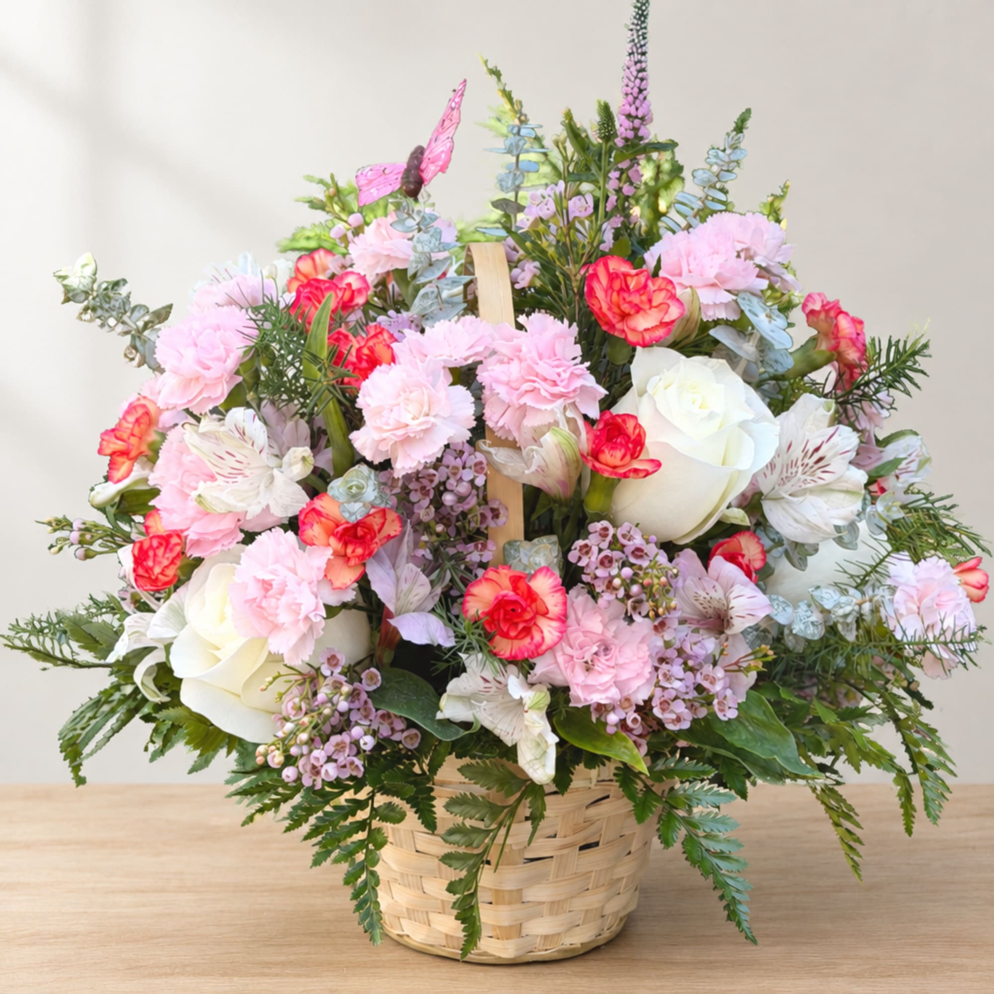 Pink and white flower arrangement in a woven basket
