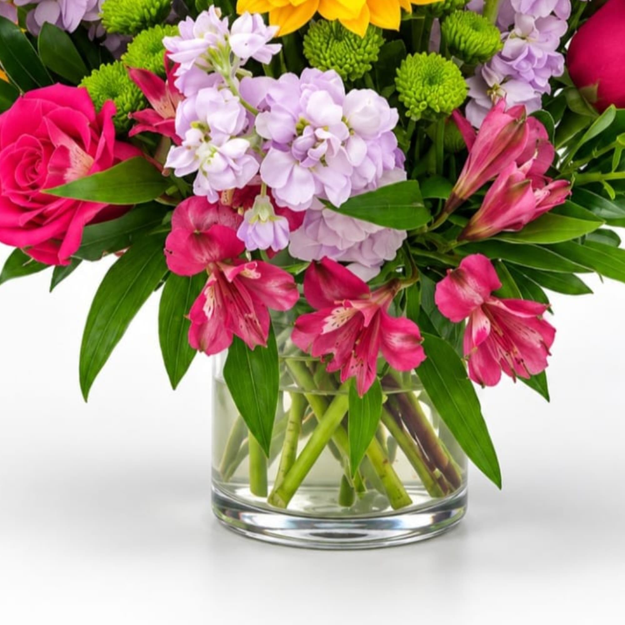 Pink and lavender flowers arranged in a clear glass vase