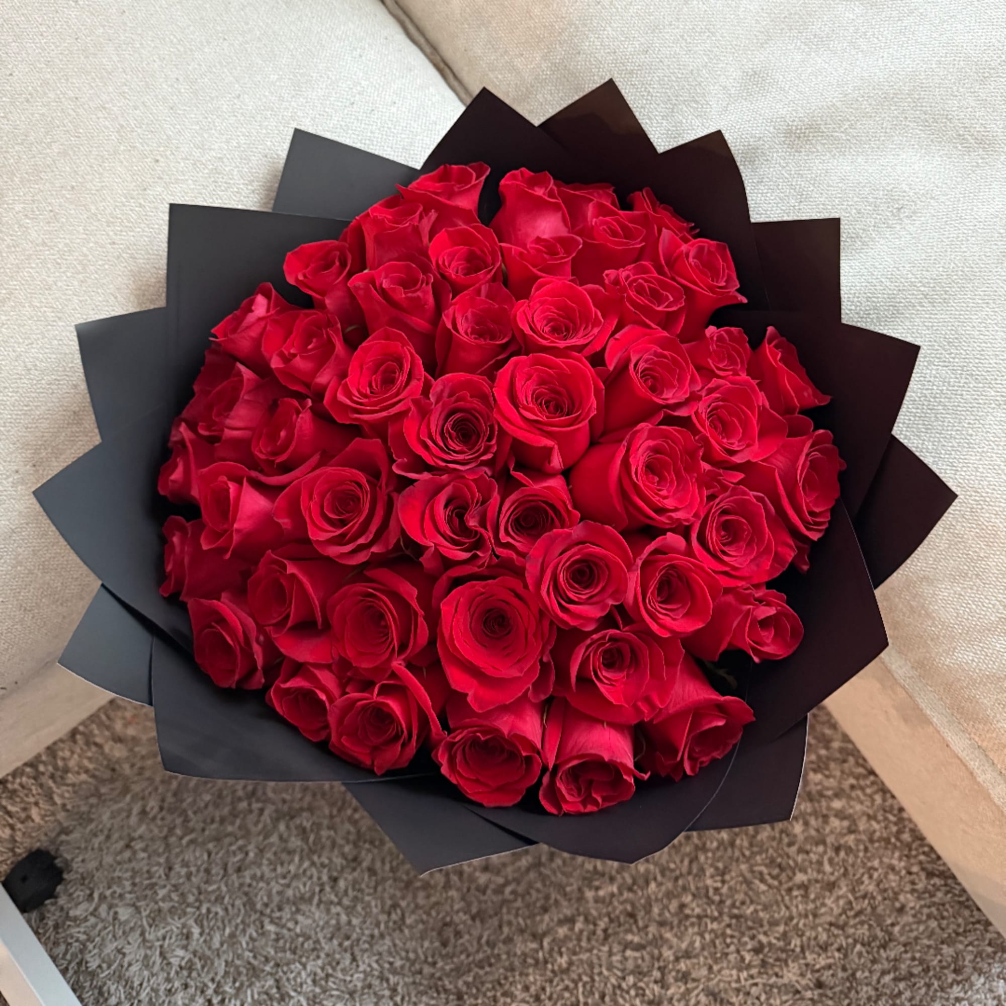Bouquet of red roses wrapped in black paper