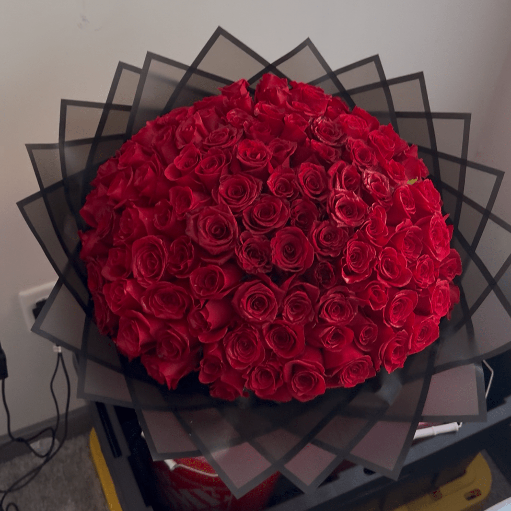 Large bouquet of red roses wrapped in black paper