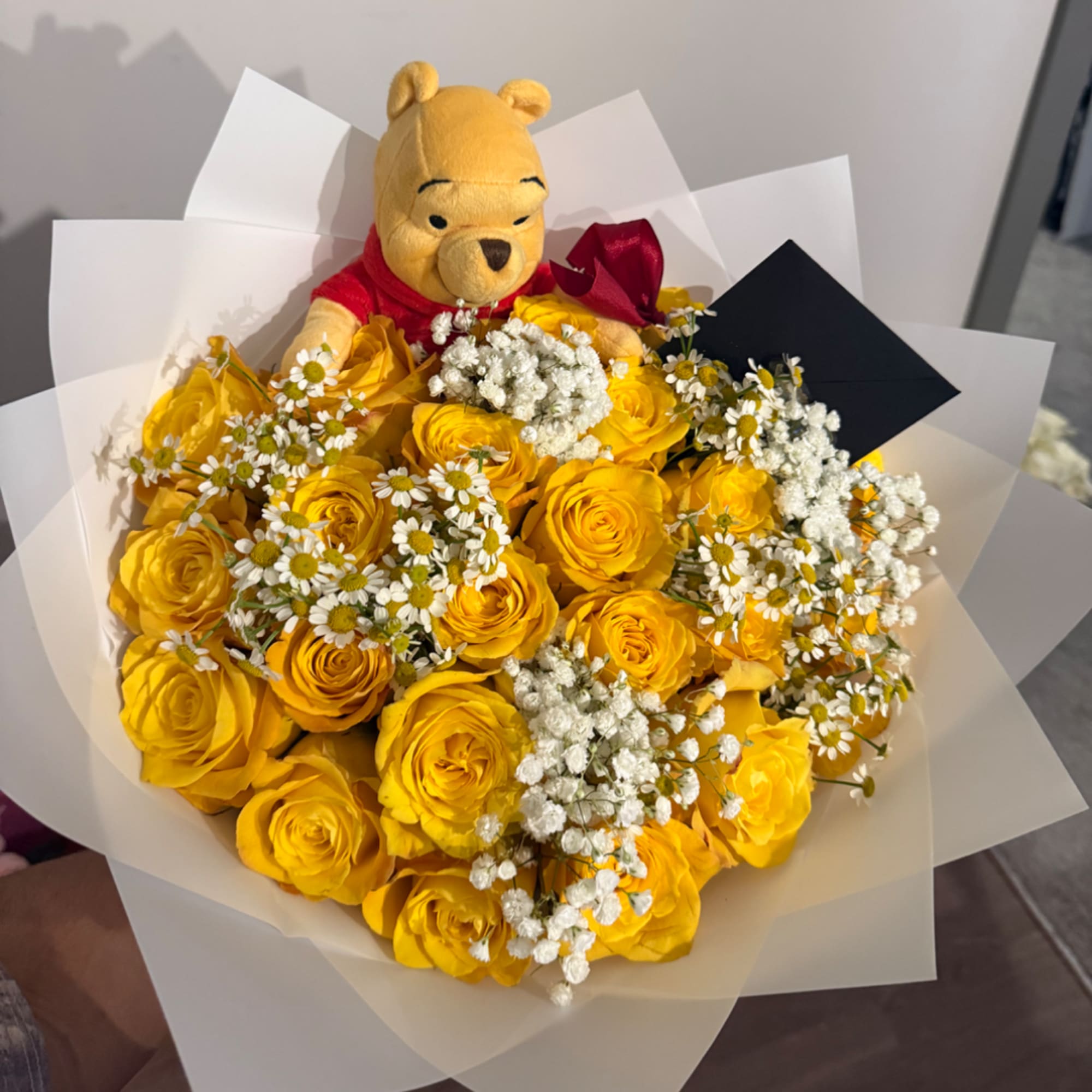 Yellow rose bouquet with baby's breath and a Winnie the Pooh plush