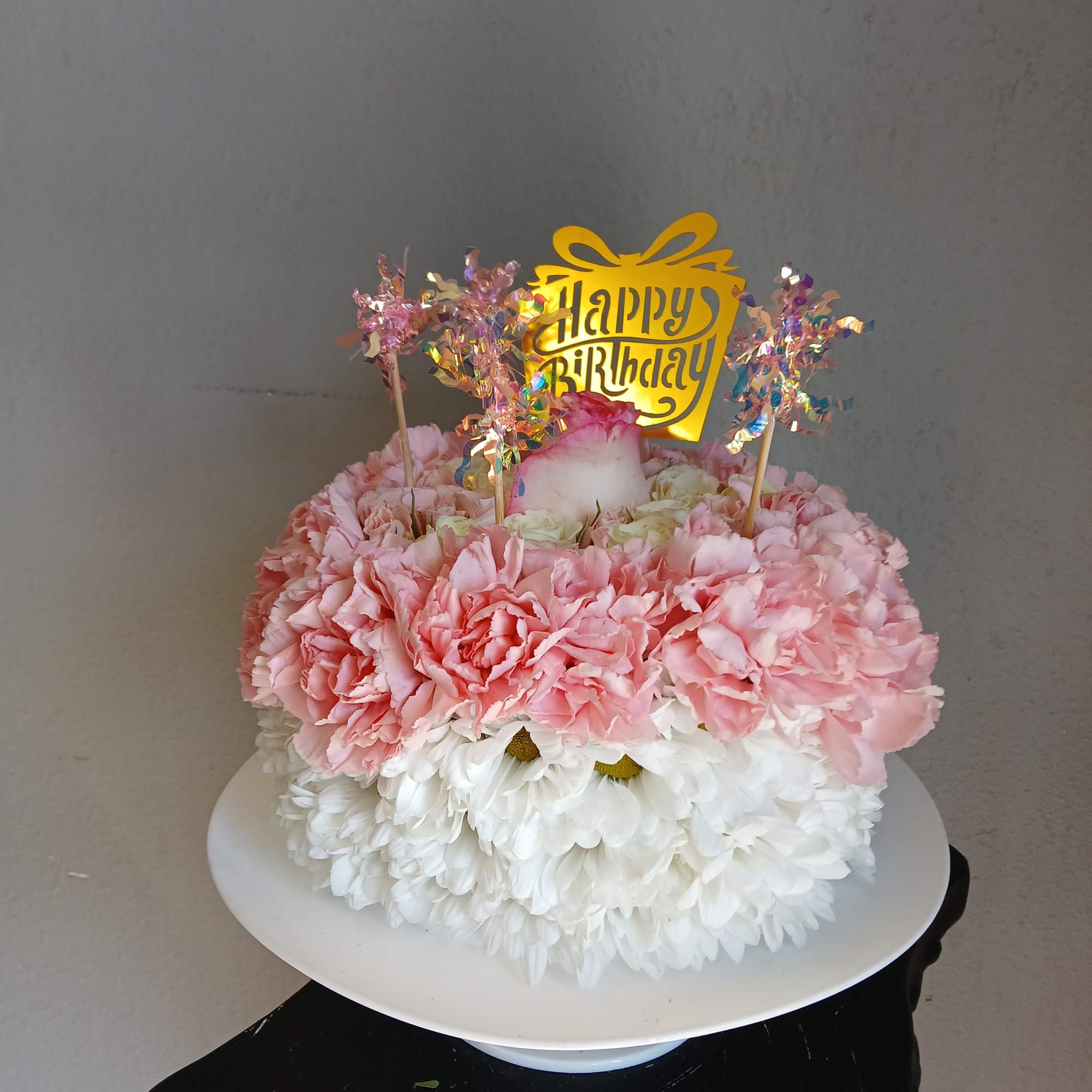 Pink and white flower cake with a happy birthday topper