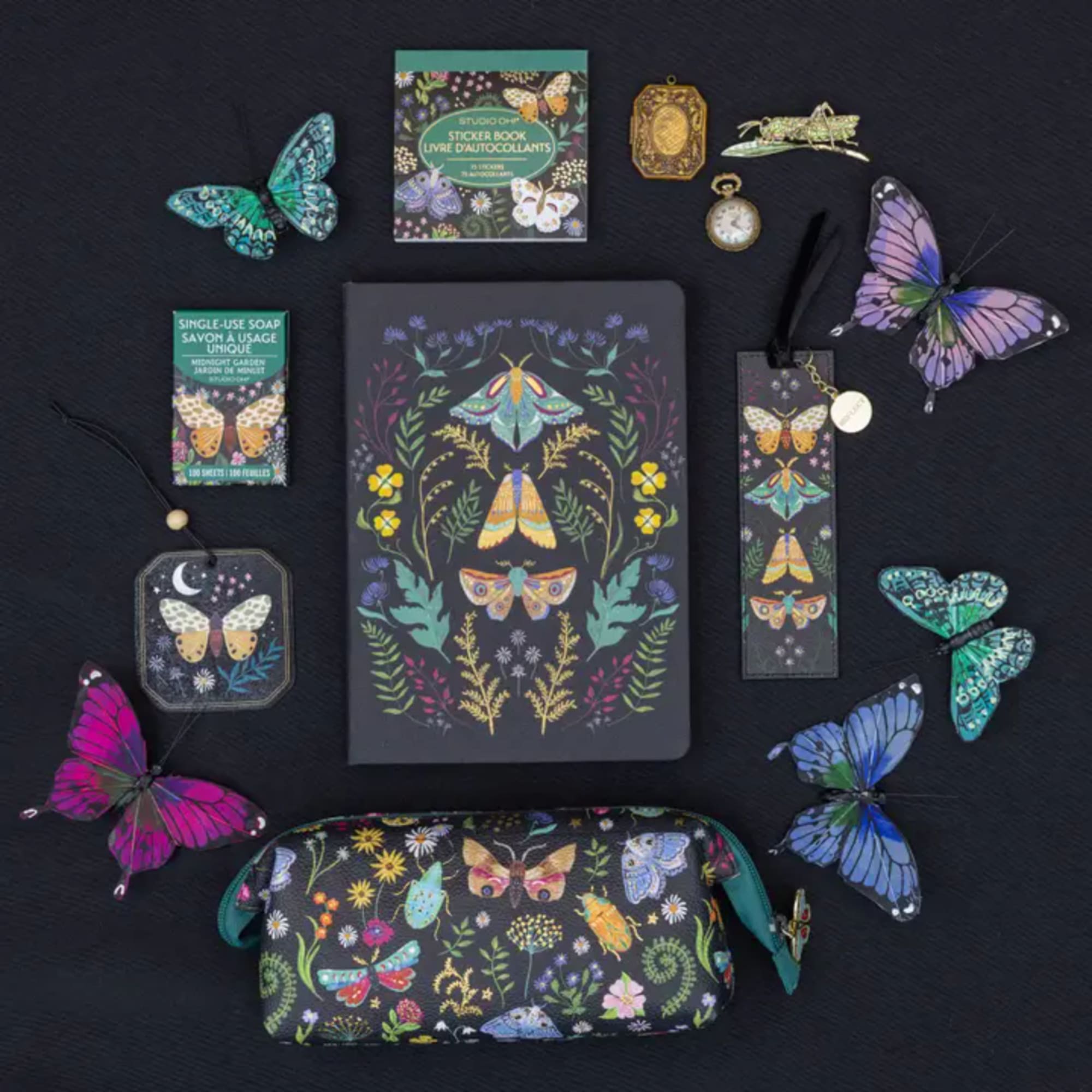 Butterfly-themed stationery and gift items arranged on a dark background