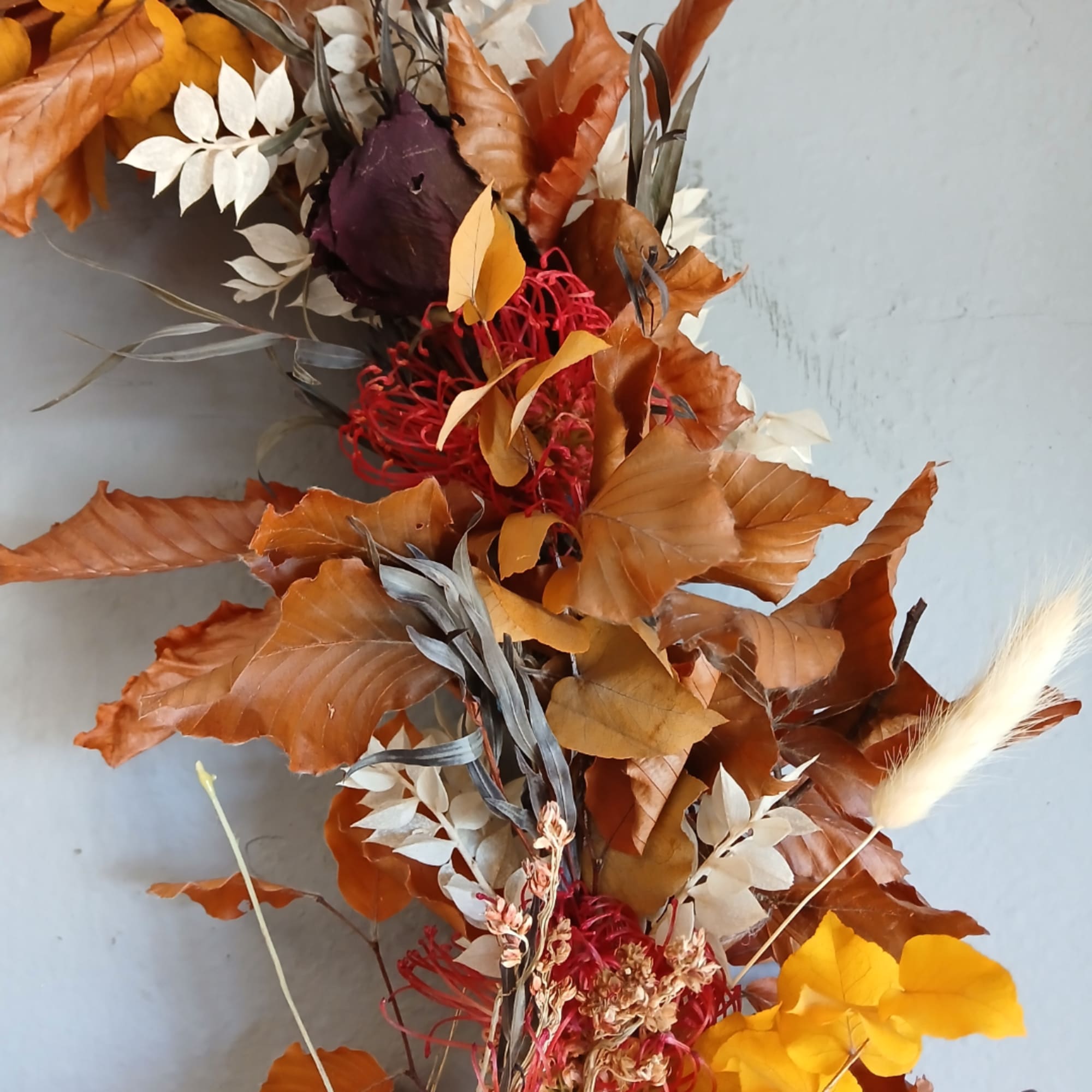 Autumn floral arrangement with orange and red foliage and dried flowers