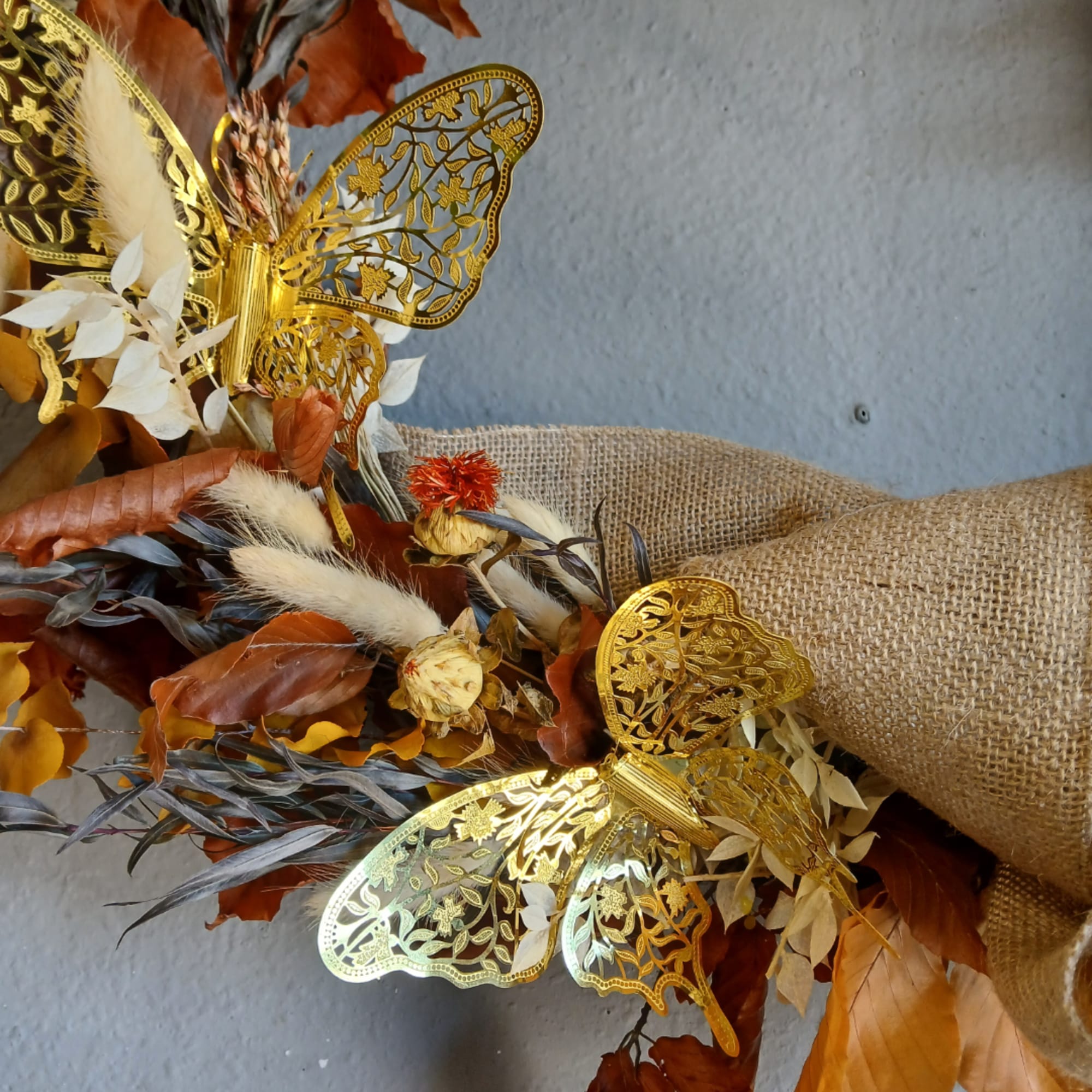 Autumn bouquet with gold butterfly decorations and burlap wrap