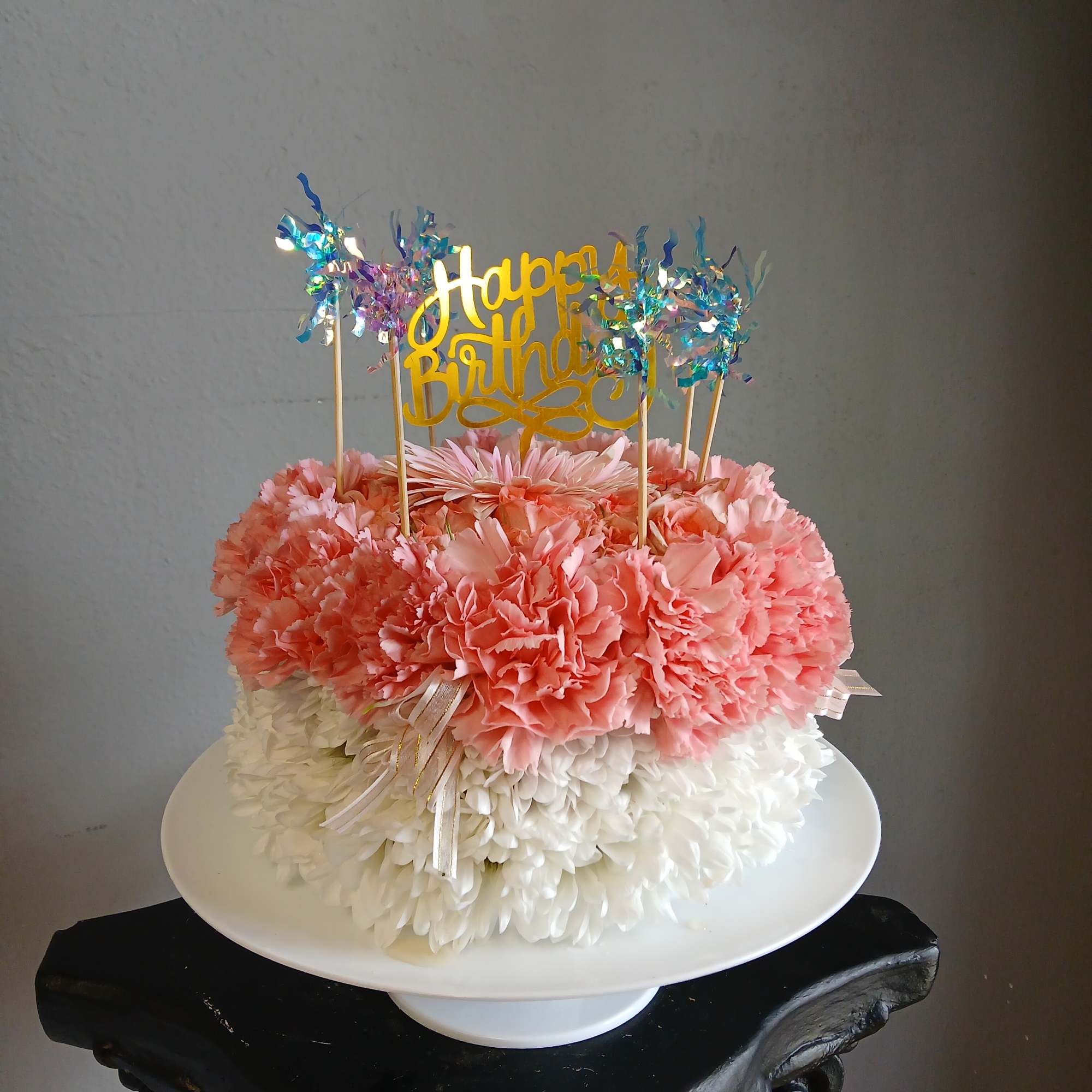 Pink and white flower cake with a Happy Birthday topper