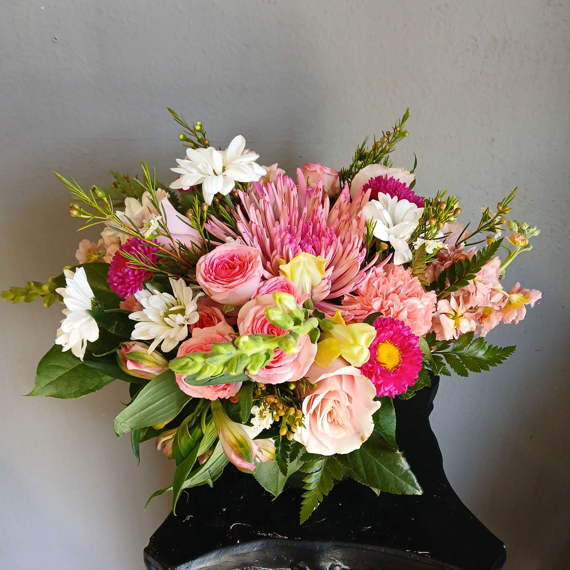 Pink and white mixed bouquet in a black vase