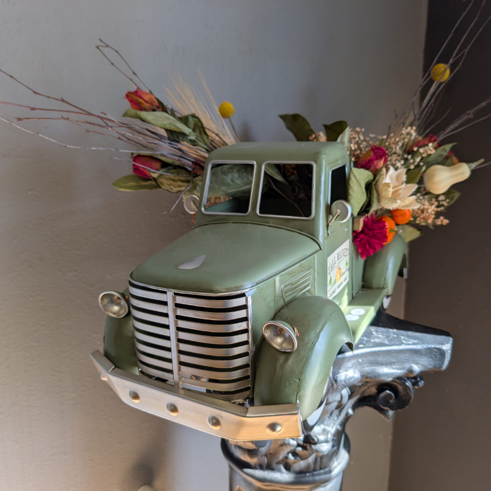 Vintage truck planter filled with mixed flowers and dried stems
