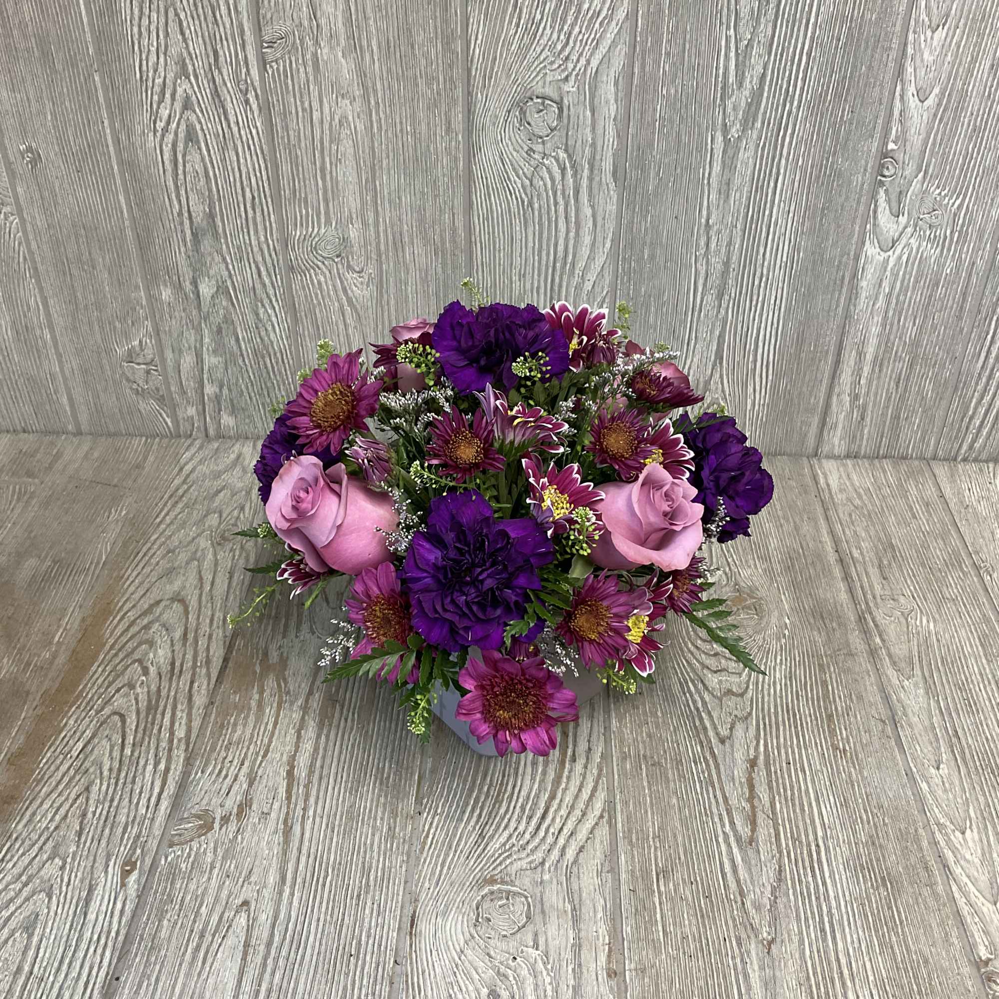 Purple and pink bouquet with roses and daisy-like flowers