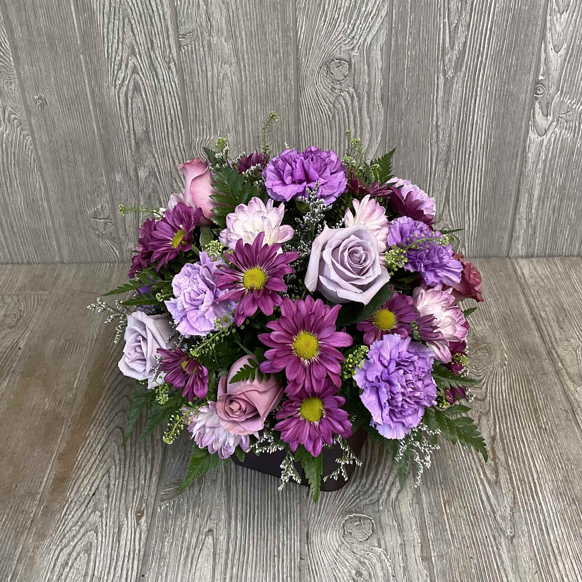 Round bouquet of purple and pink flowers with lavender roses