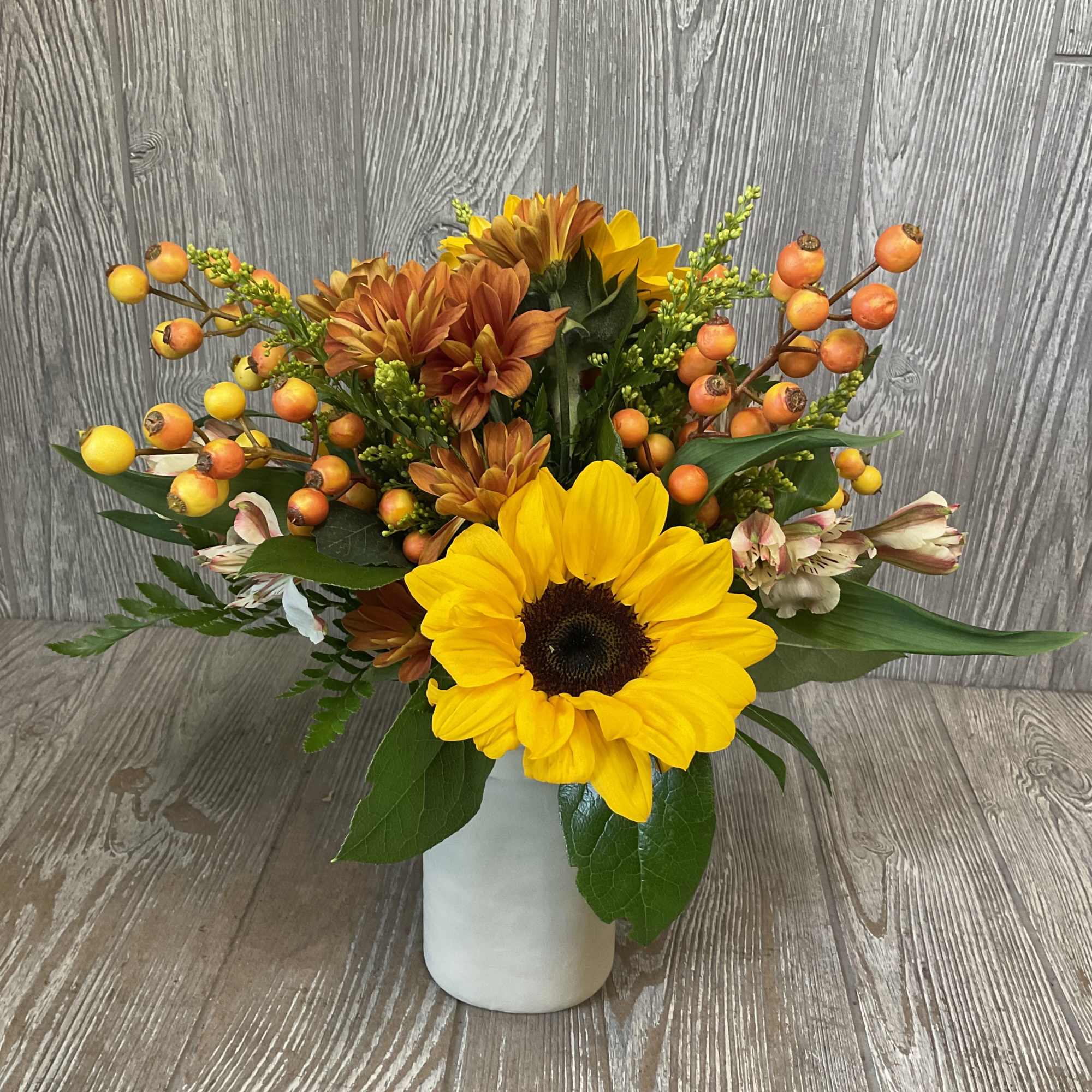 Sunflower and autumn bouquet in a white vase