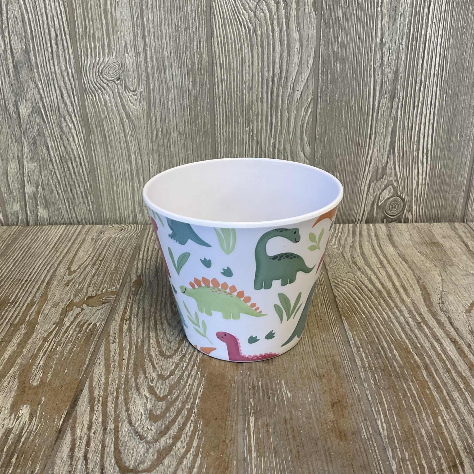 Small paper cup with colorful dinosaur illustrations