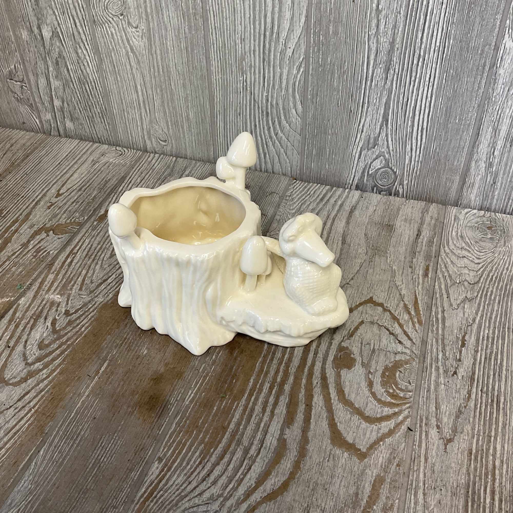 Cream ceramic planter shaped like a tree stump with mushrooms and a rabbit figure