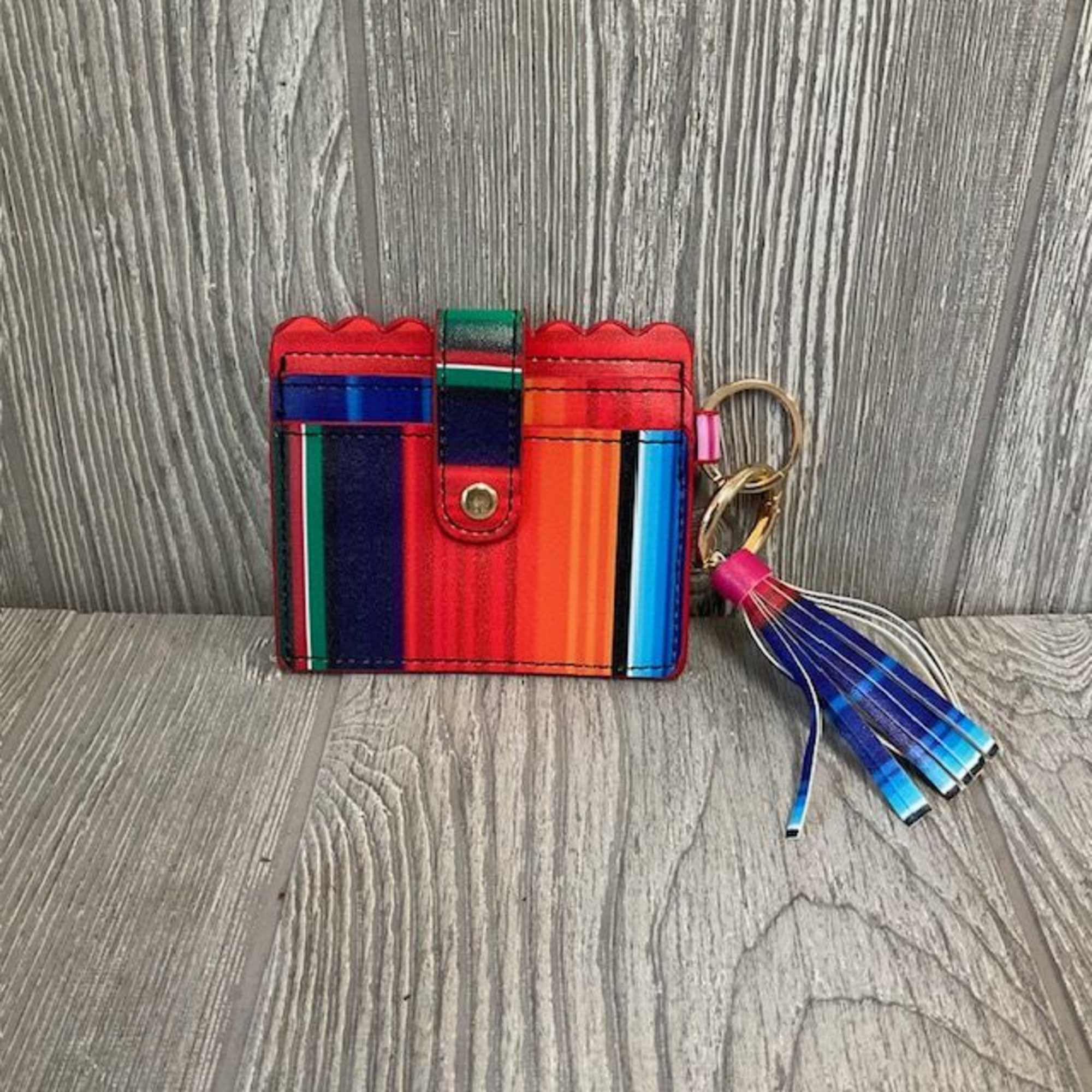 Colorful striped wallet with a tassel keychain on a wood surface