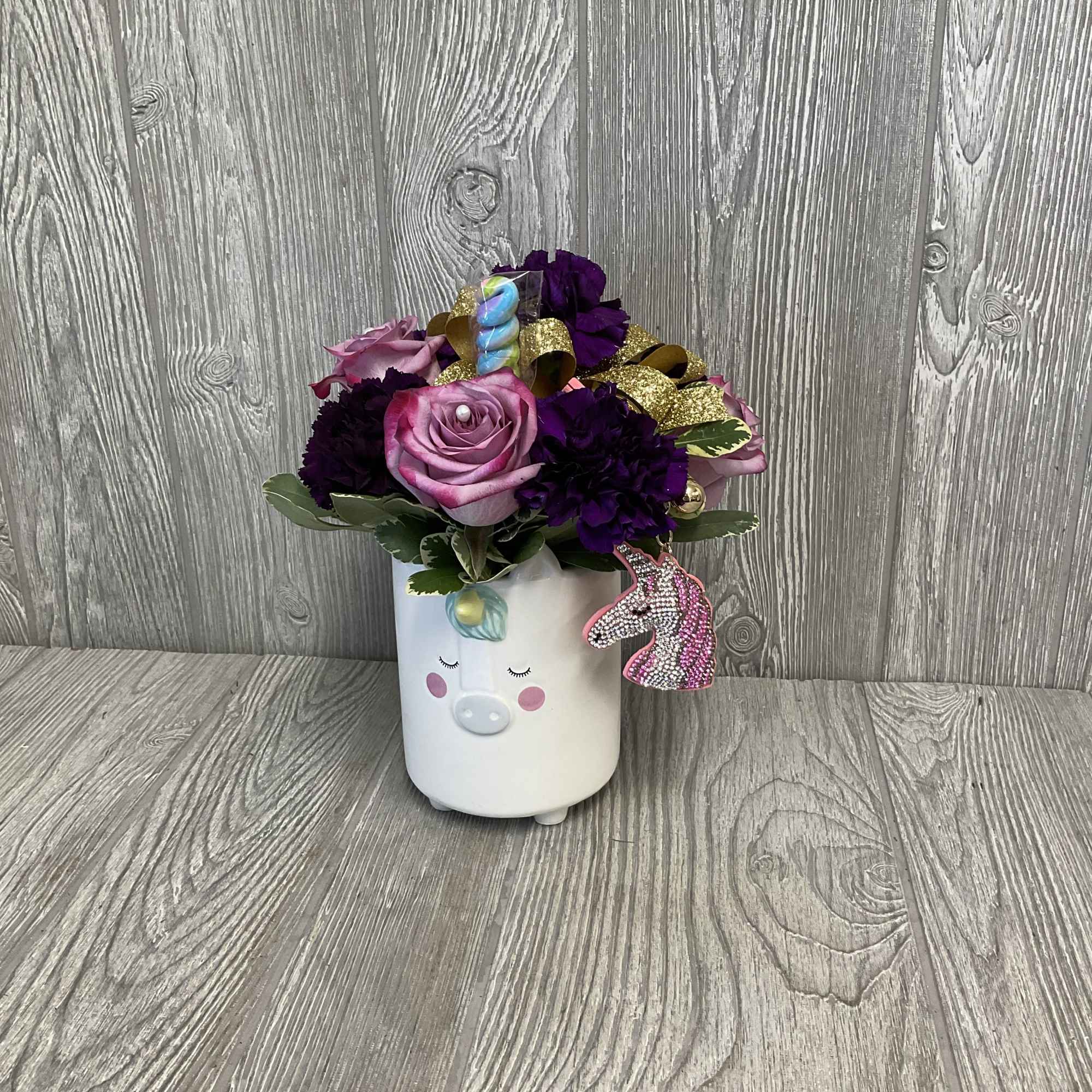 Pink and purple roses in a white unicorn planter