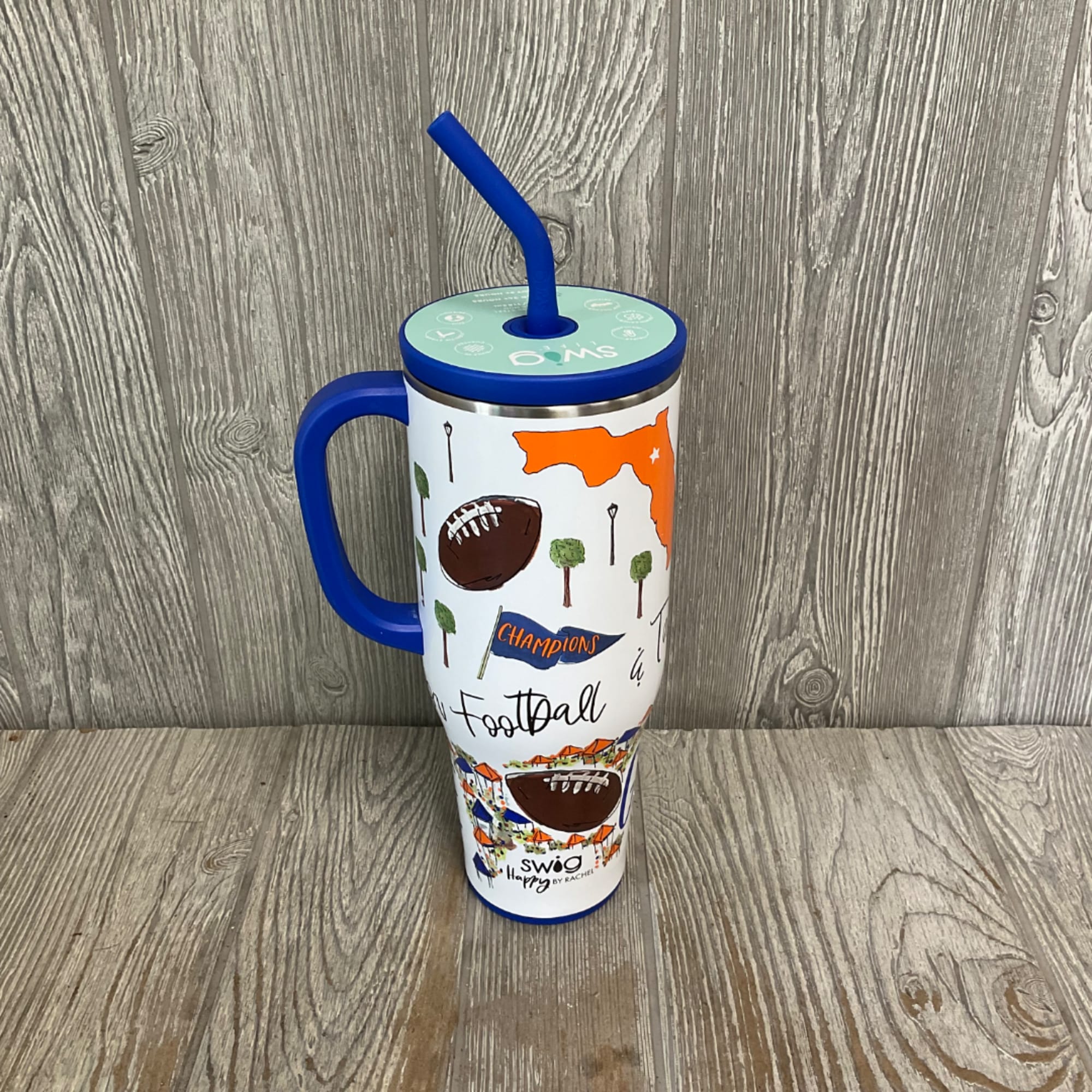 Football-themed insulated tumbler with a blue lid, handle, and straw