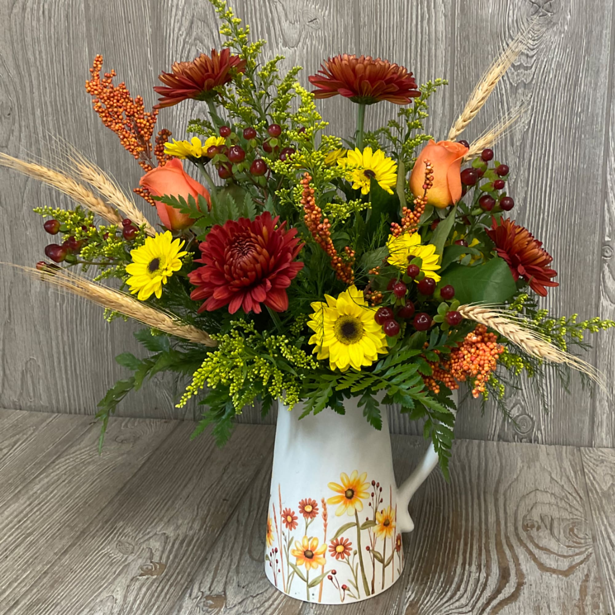Mixed bouquet in a white pitcher vase with yellow and red flowers