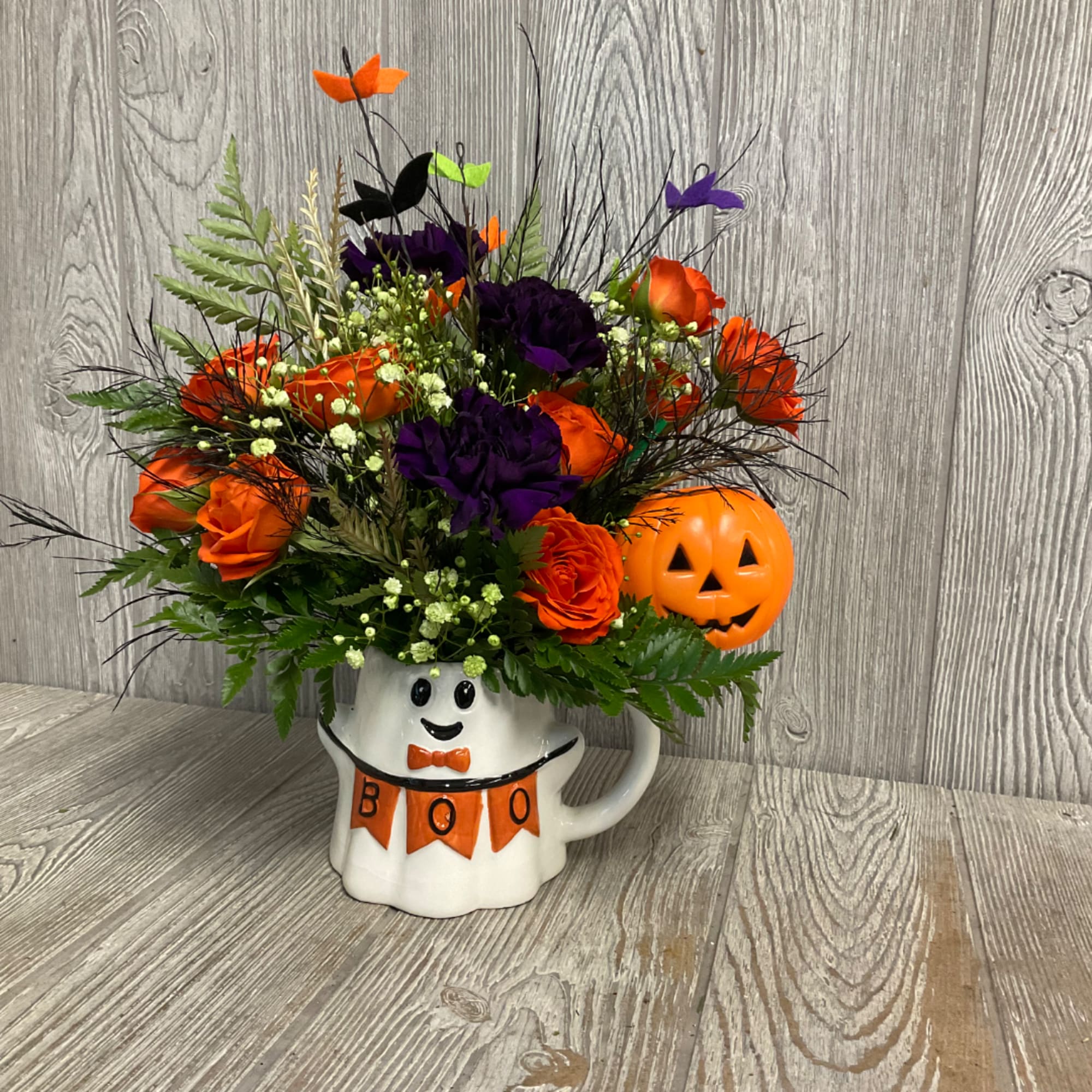 Halloween bouquet in a ghost mug with orange and purple flowers