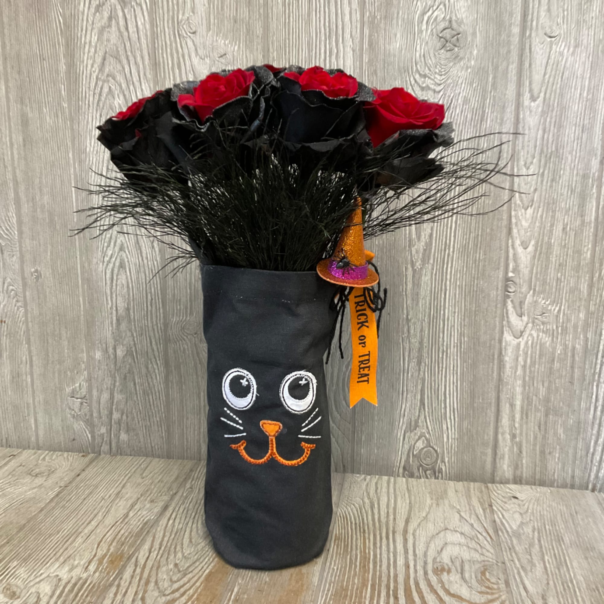 Black and red rose bouquet in a cat-themed Halloween sleeve