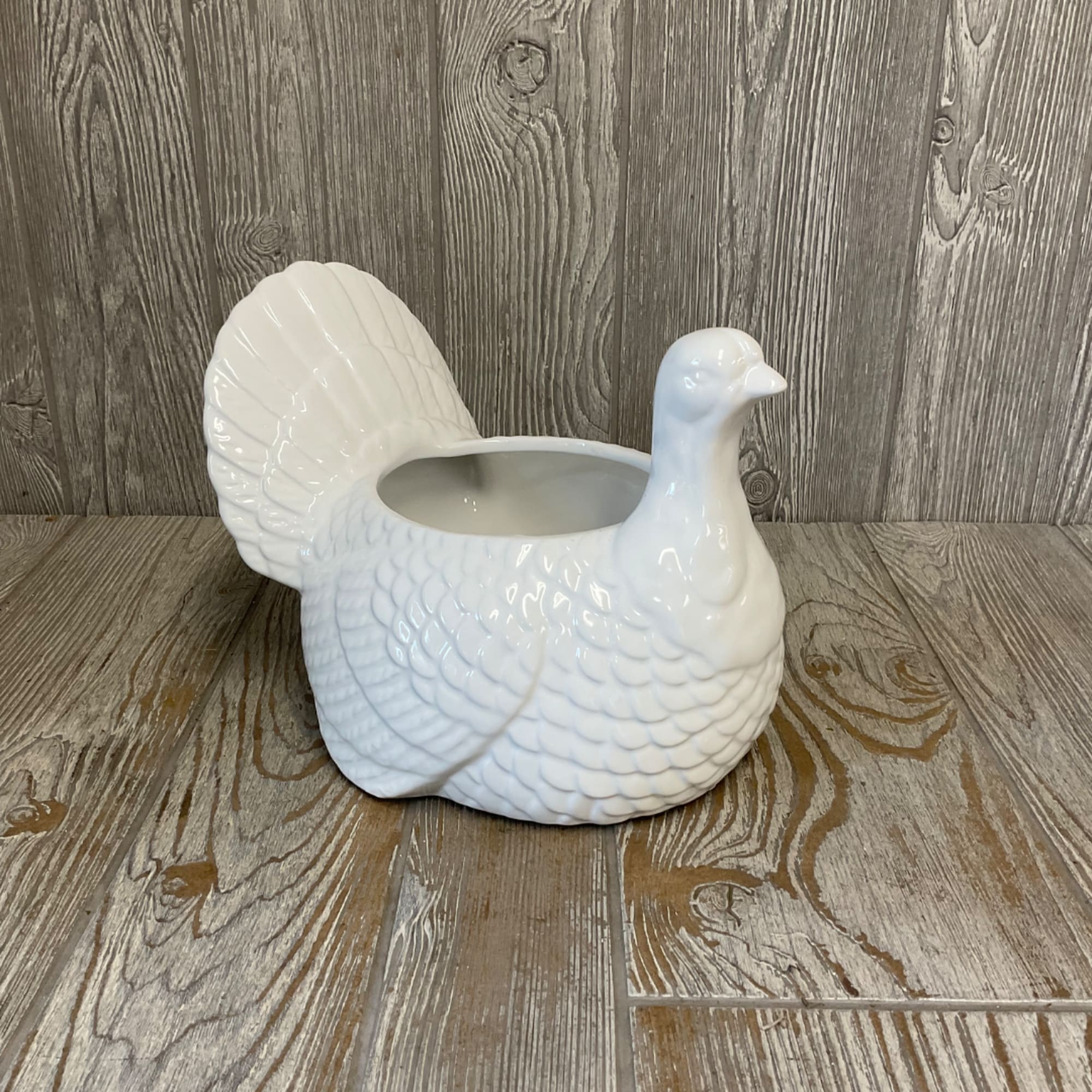 White ceramic turkey-shaped planter on a wood floor