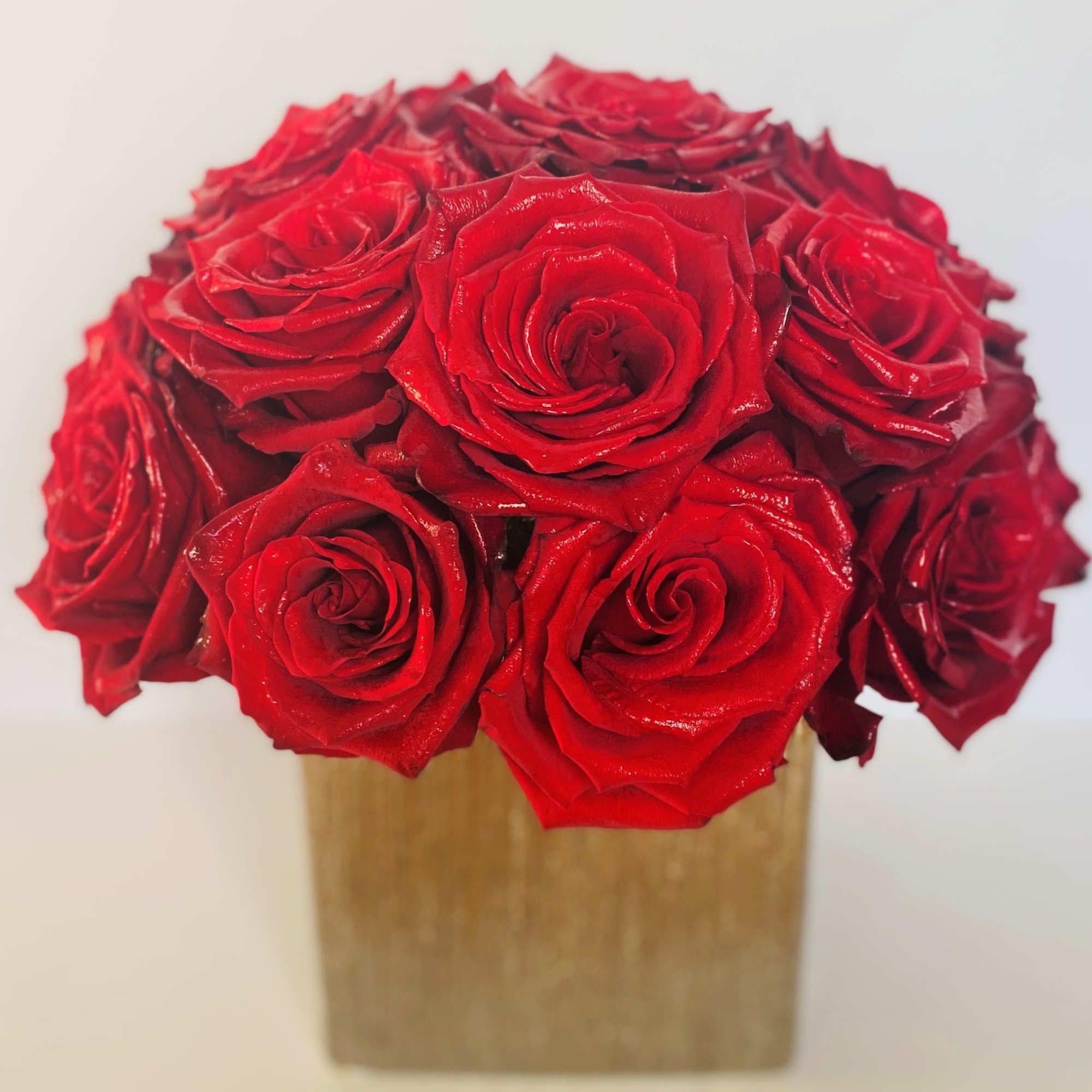 Bouquet of red roses in a square gold box