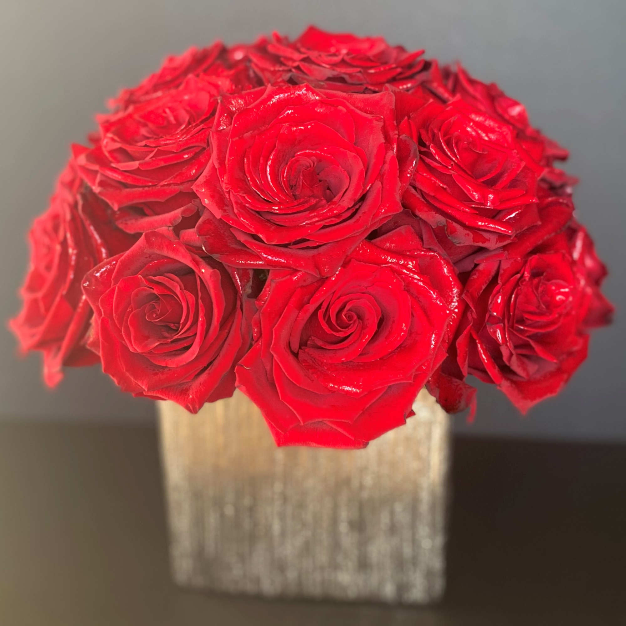 Red roses arranged in a square metallic vase
