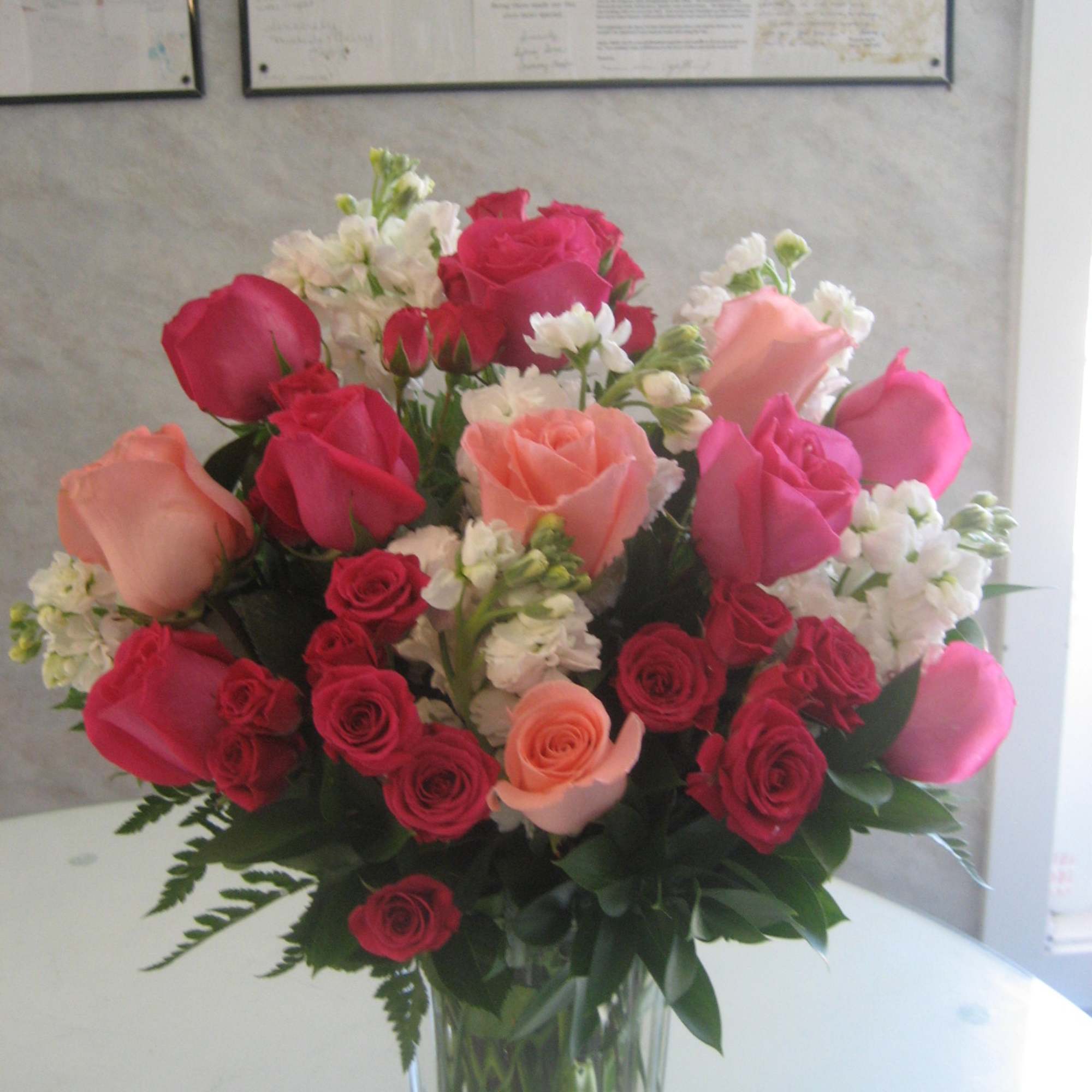 Light Pink and Dark Pink Roses come beautifully arranged in a glass