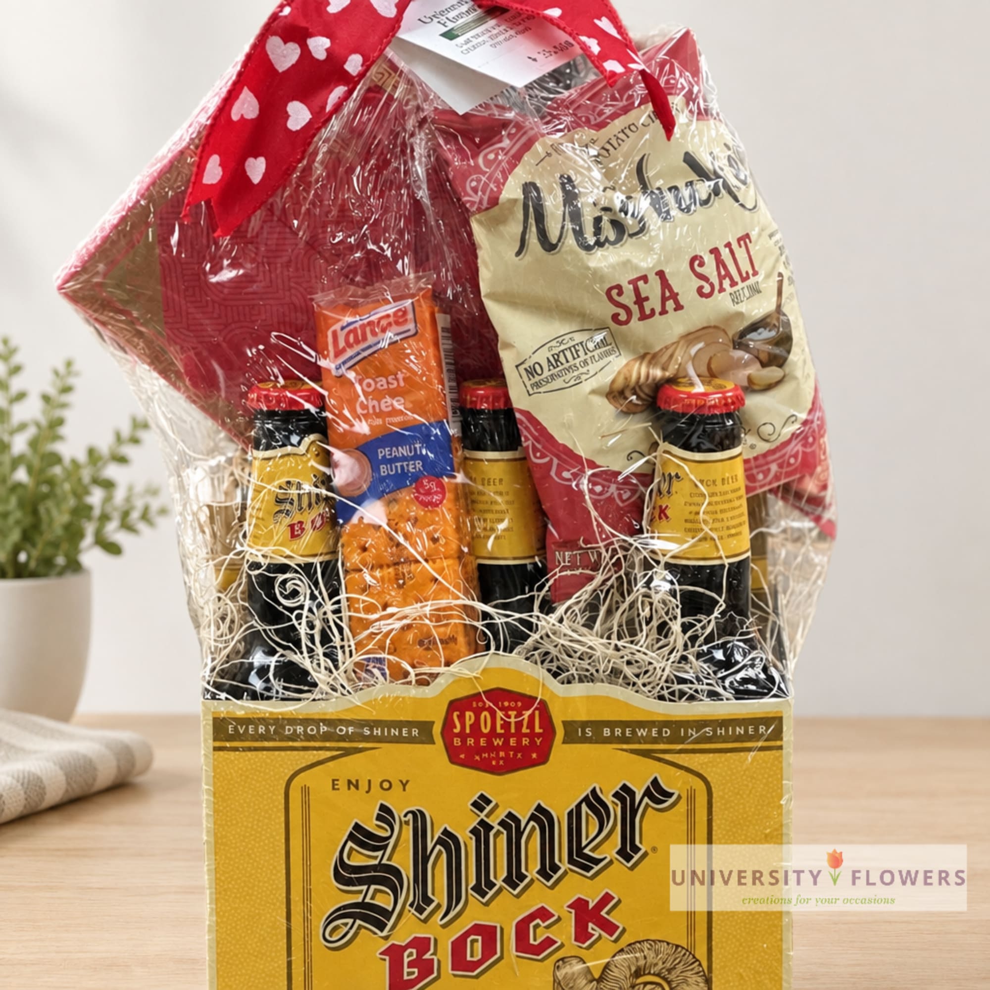 Gift basket with beer bottles and snacks wrapped in clear cellophane
