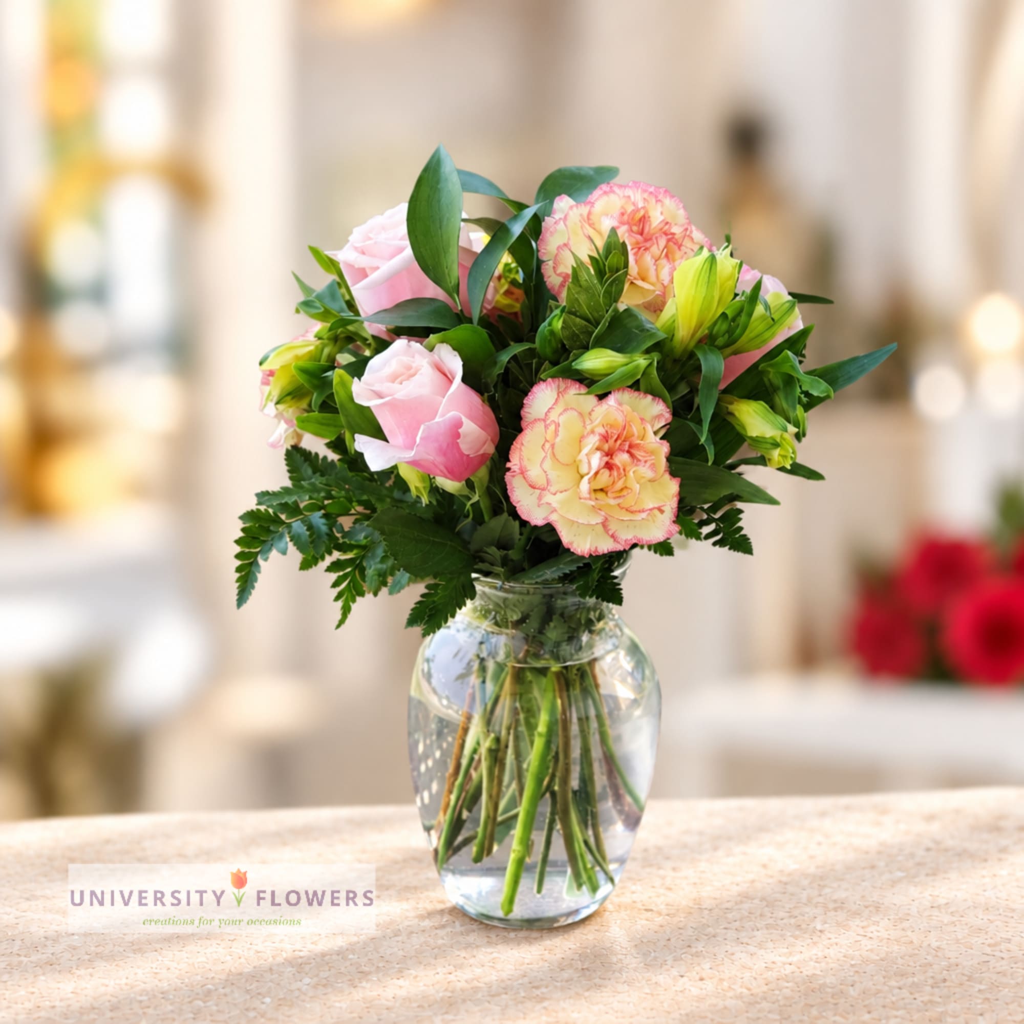 Pink roses and carnations in a clear glass vase