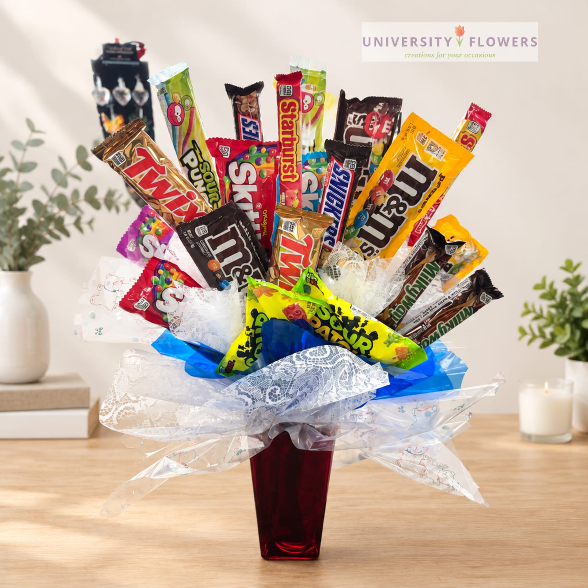 Candy bouquet in a red vase with assorted chocolate bars and sweets