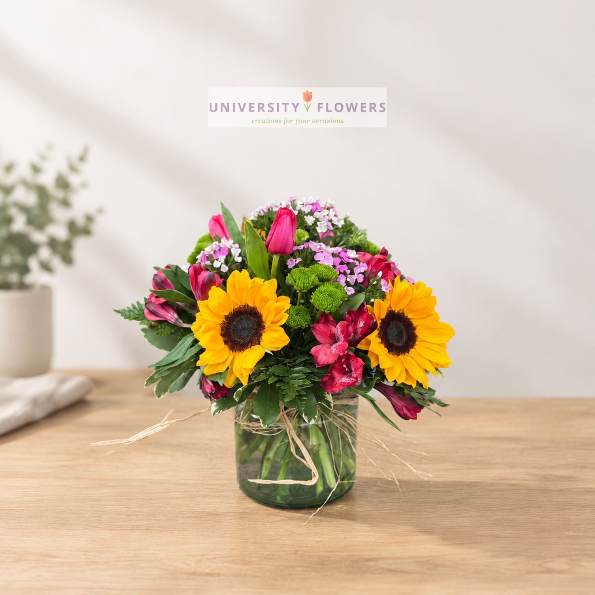 Mixed bouquet with sunflowers and pink alstroemeria in a glass vase