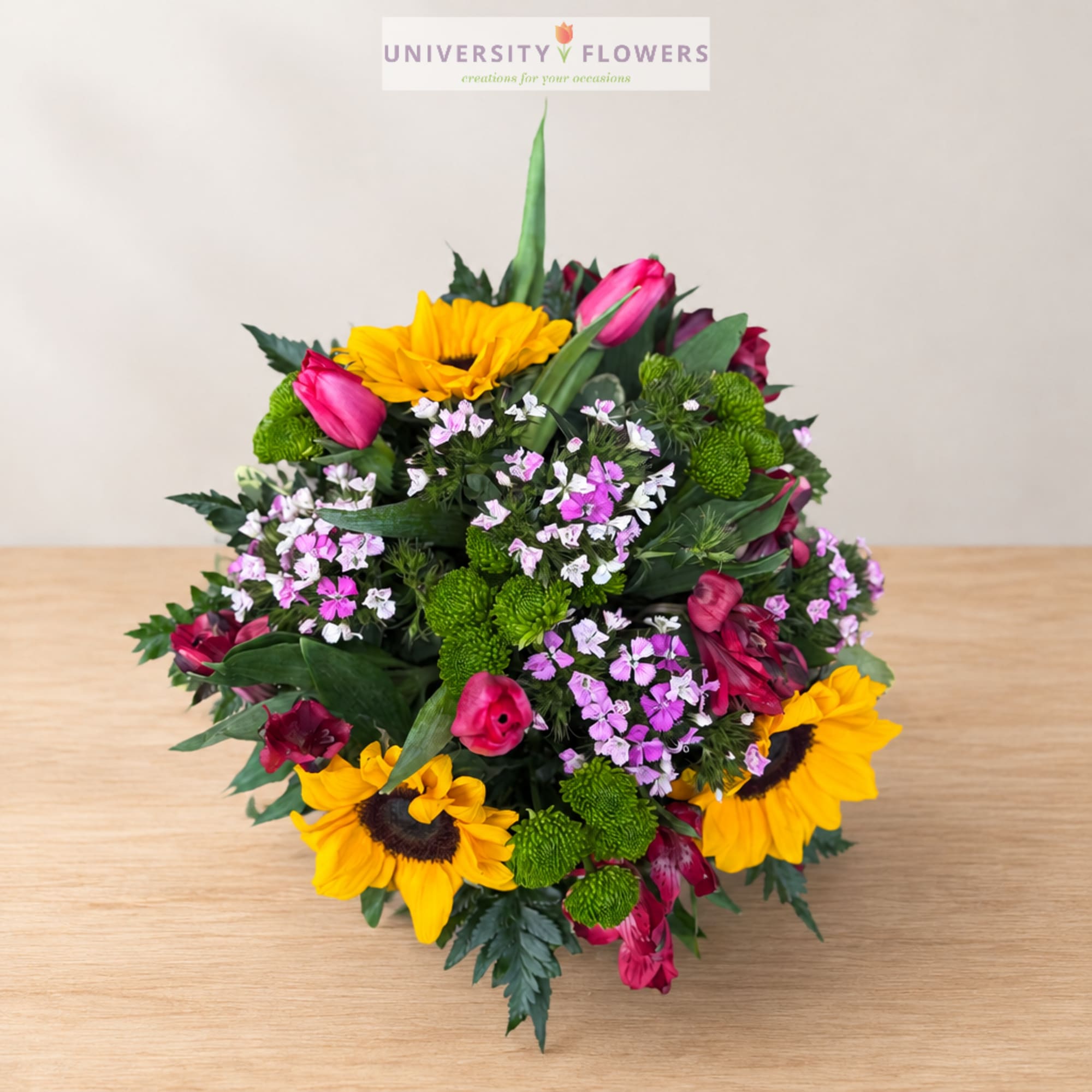 Mixed bouquet with sunflowers, pink tulips, and small purple flowers