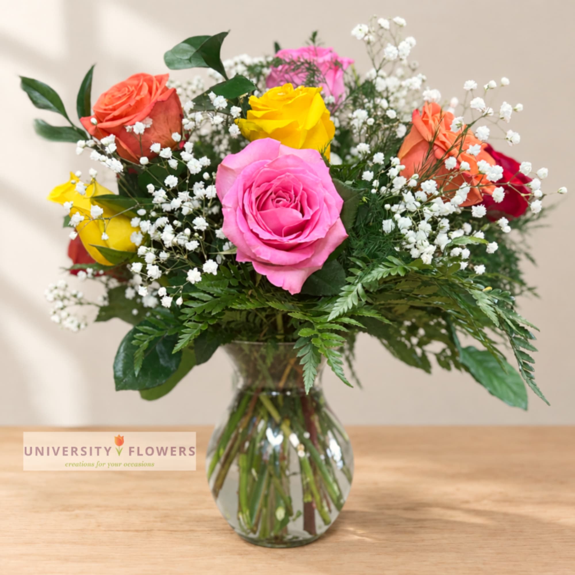 Mixed roses in a glass vase with baby's breath