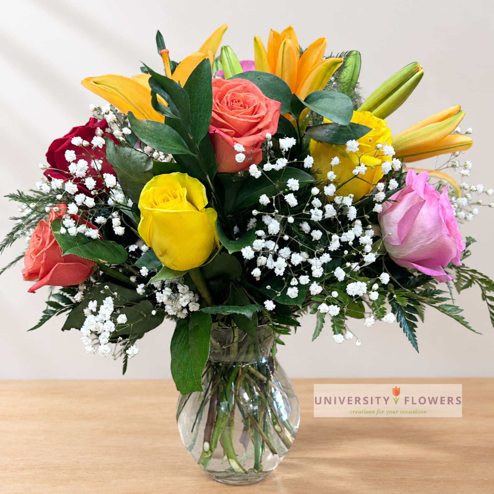 Mixed roses and lilies in a clear glass vase