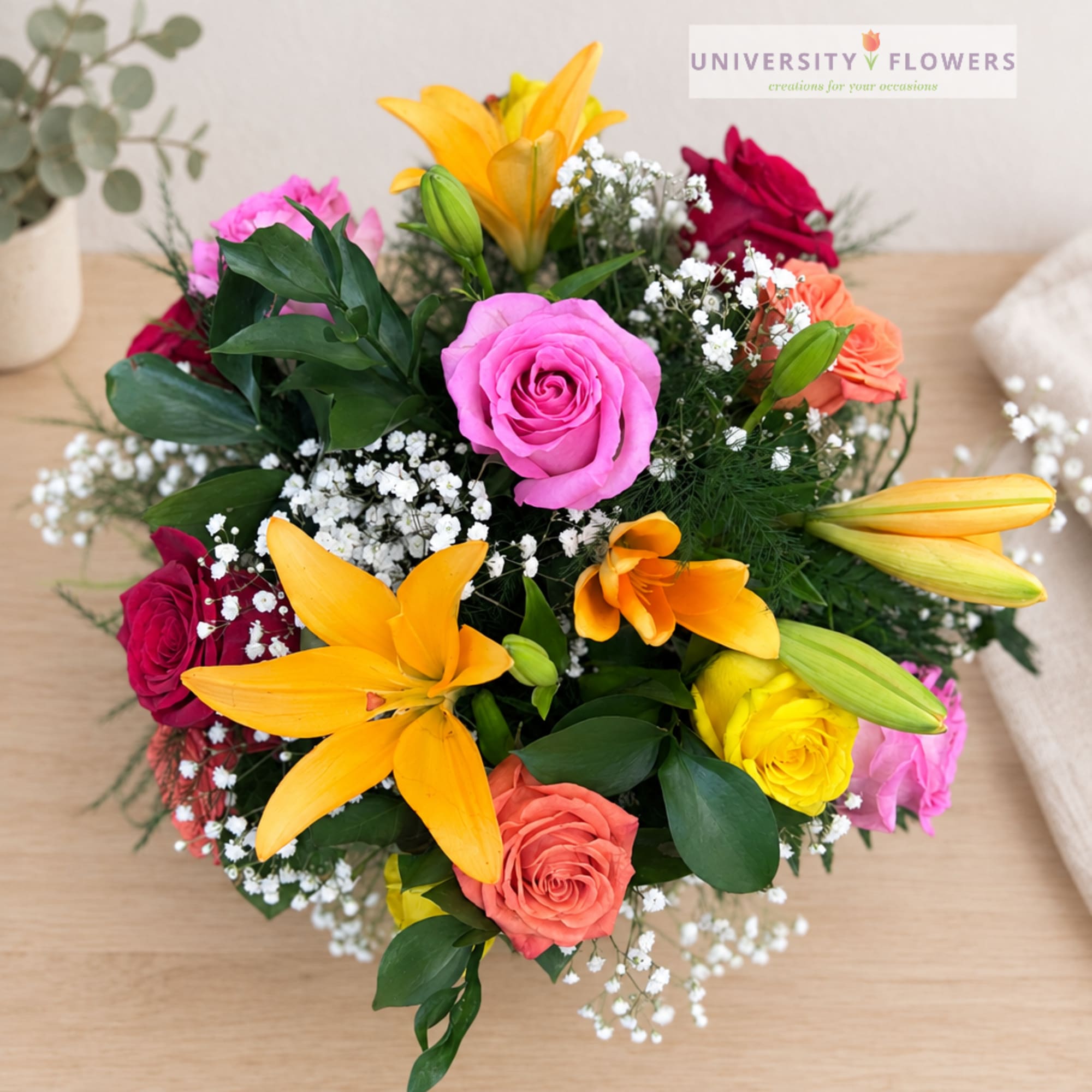 Mixed bouquet with roses, lilies, and baby's breath in bright colors