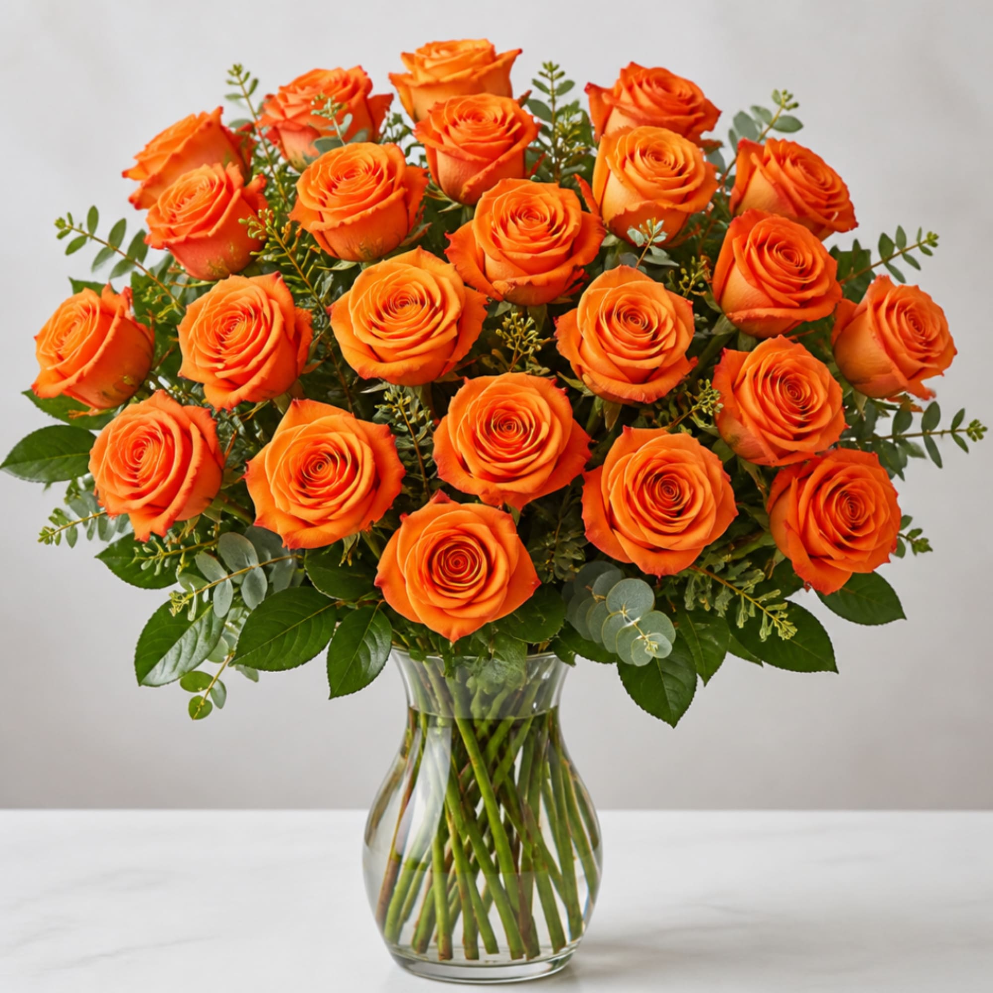 Orange roses arranged in a clear glass vase
