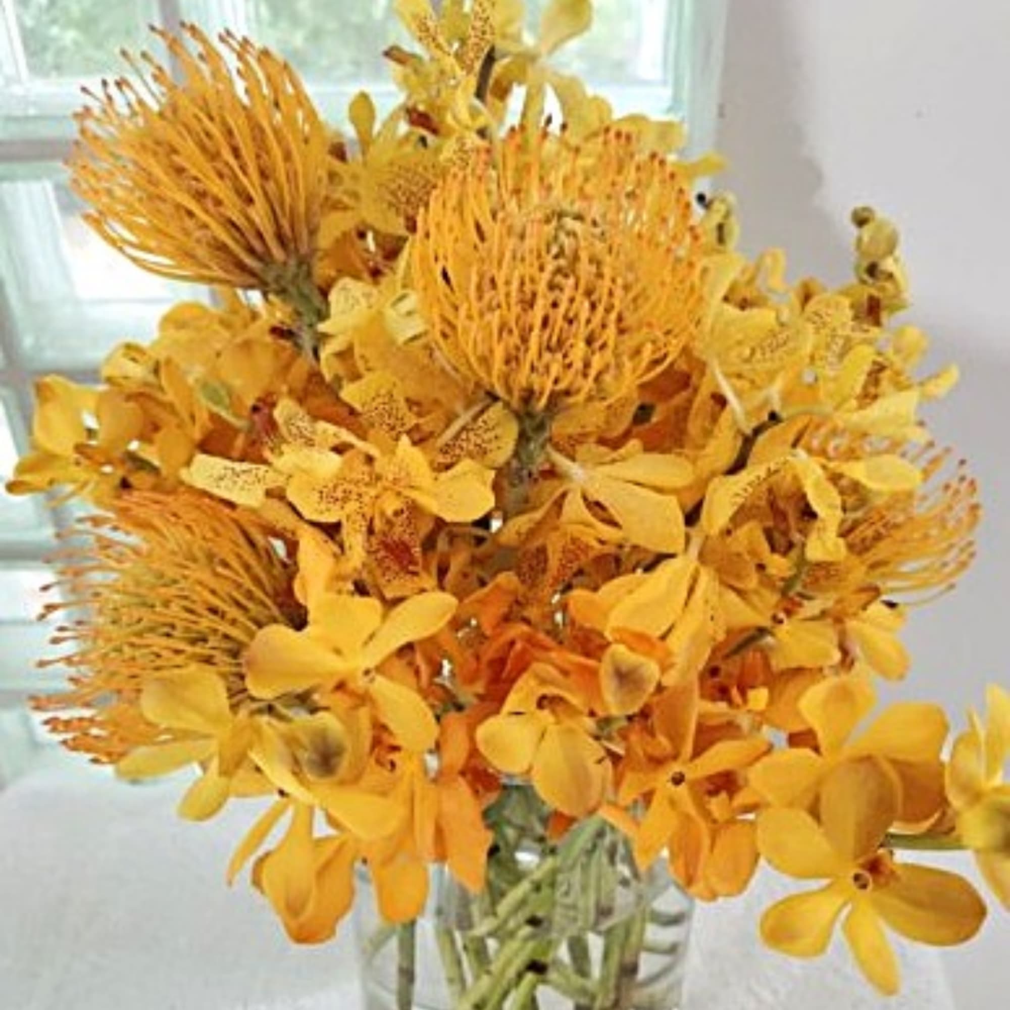 Yellow floral arrangement in a clear glass vase
