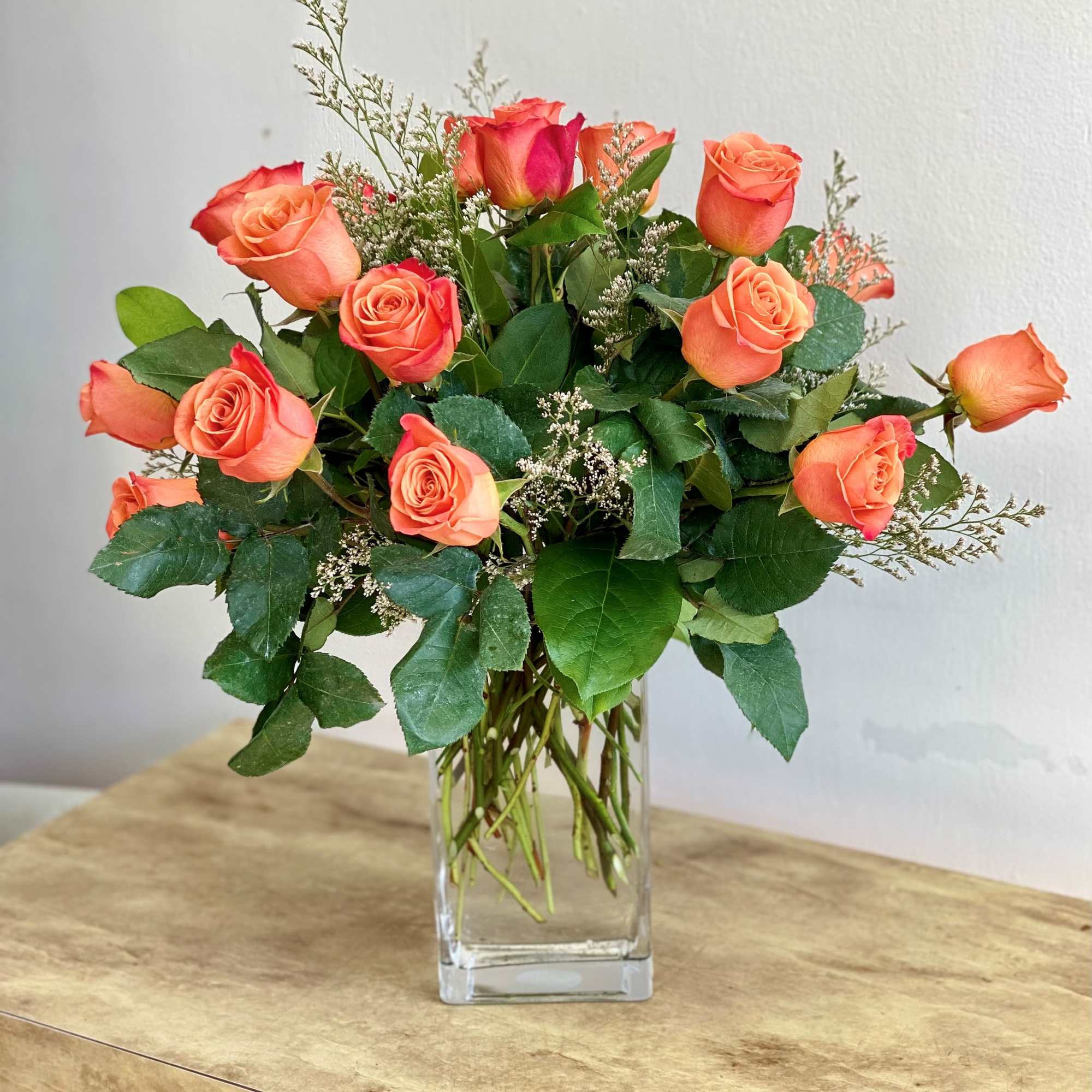 Orange roses arranged in a clear glass vase