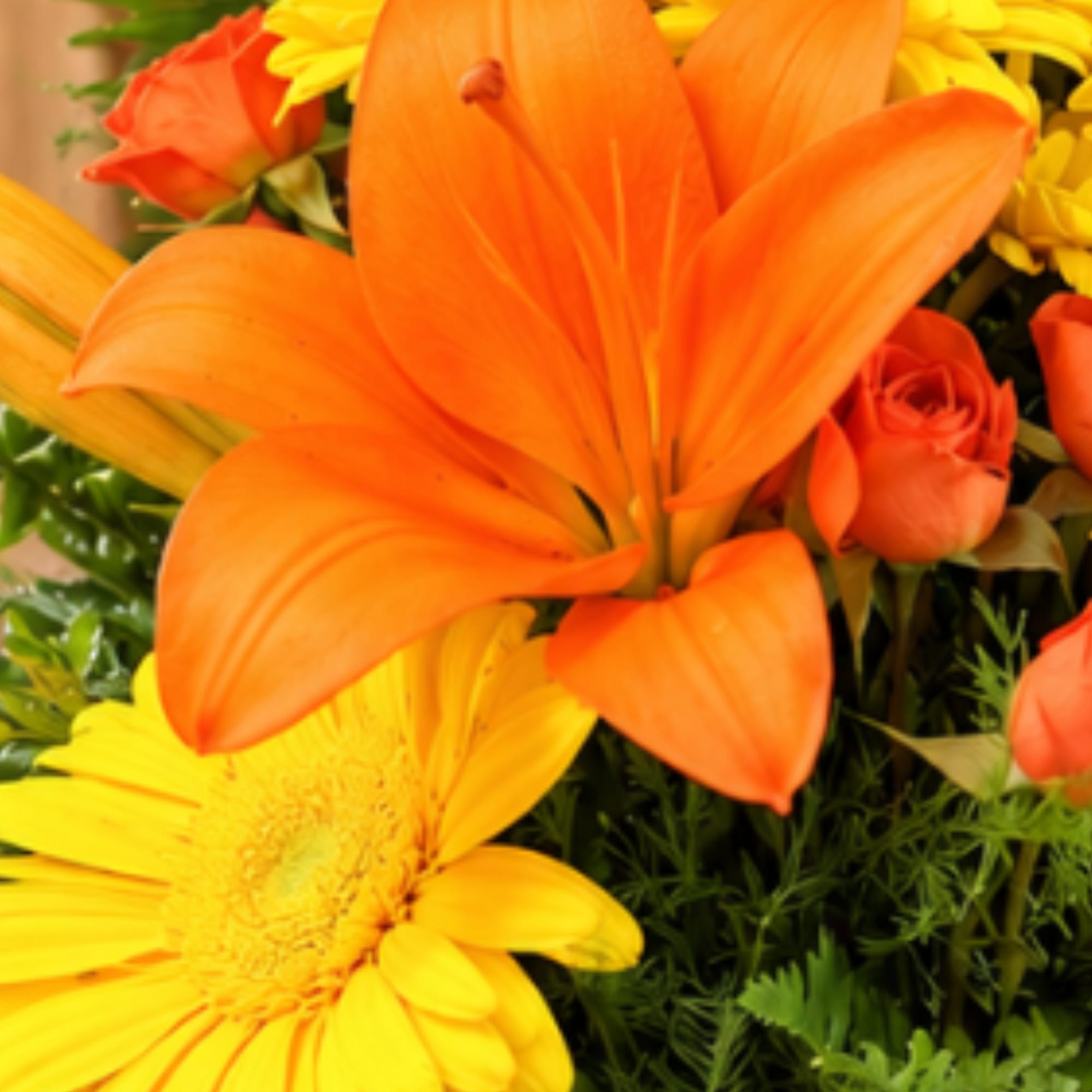 Orange lilies and yellow daisies with small orange roses