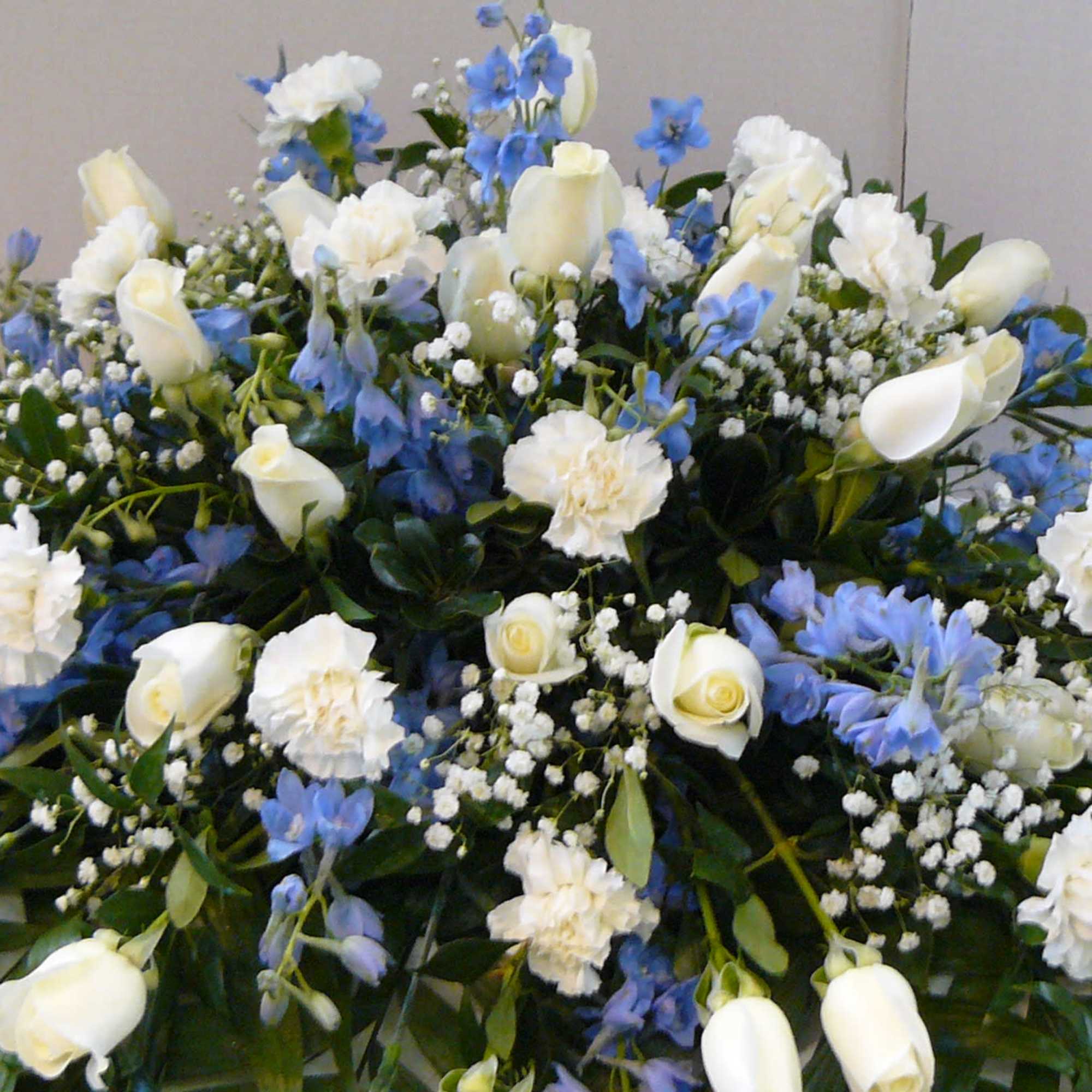 Large white and blue floral arrangement with roses and carnations