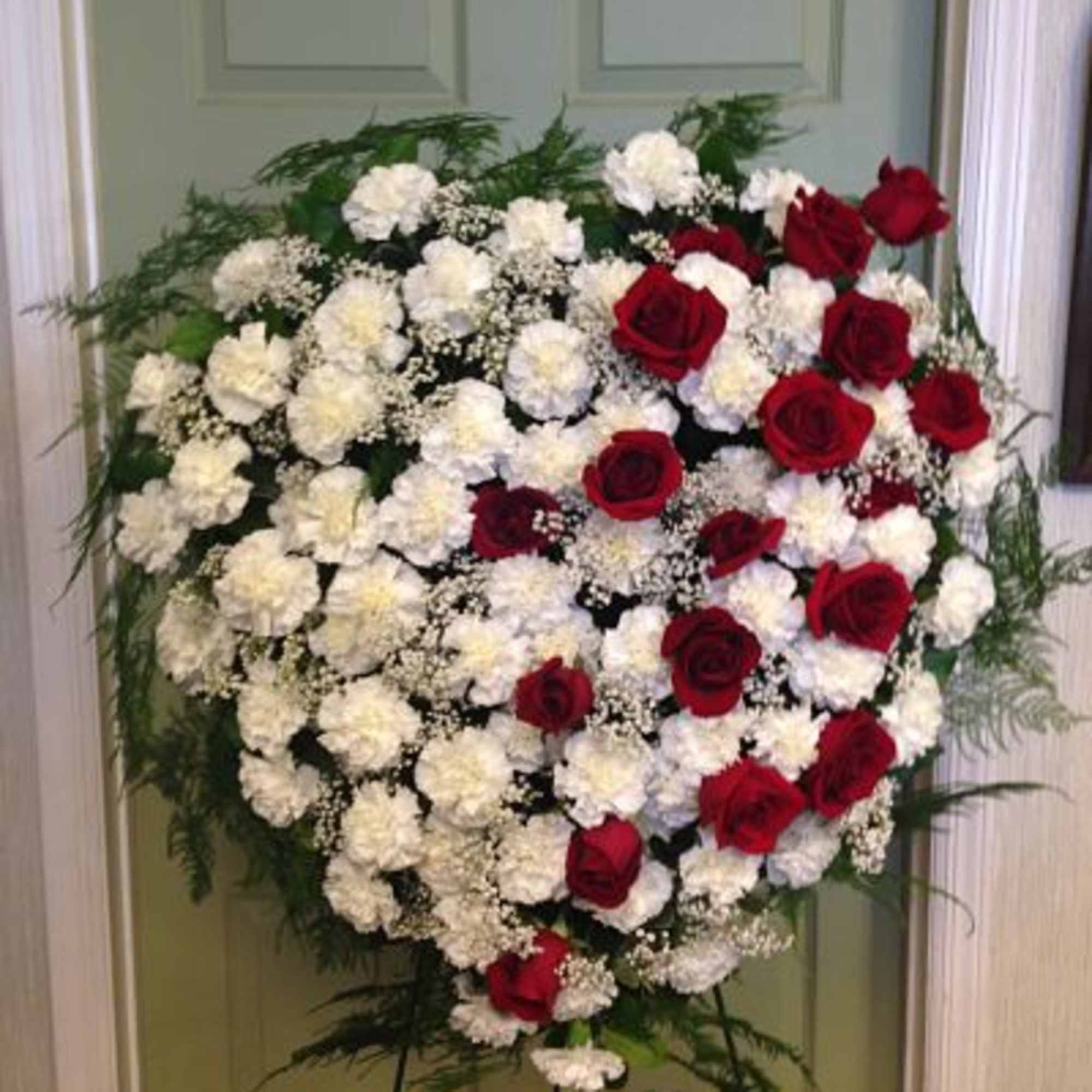 Heart-shaped standing spray of red roses and white carnations on an easel, photo 2 of 4